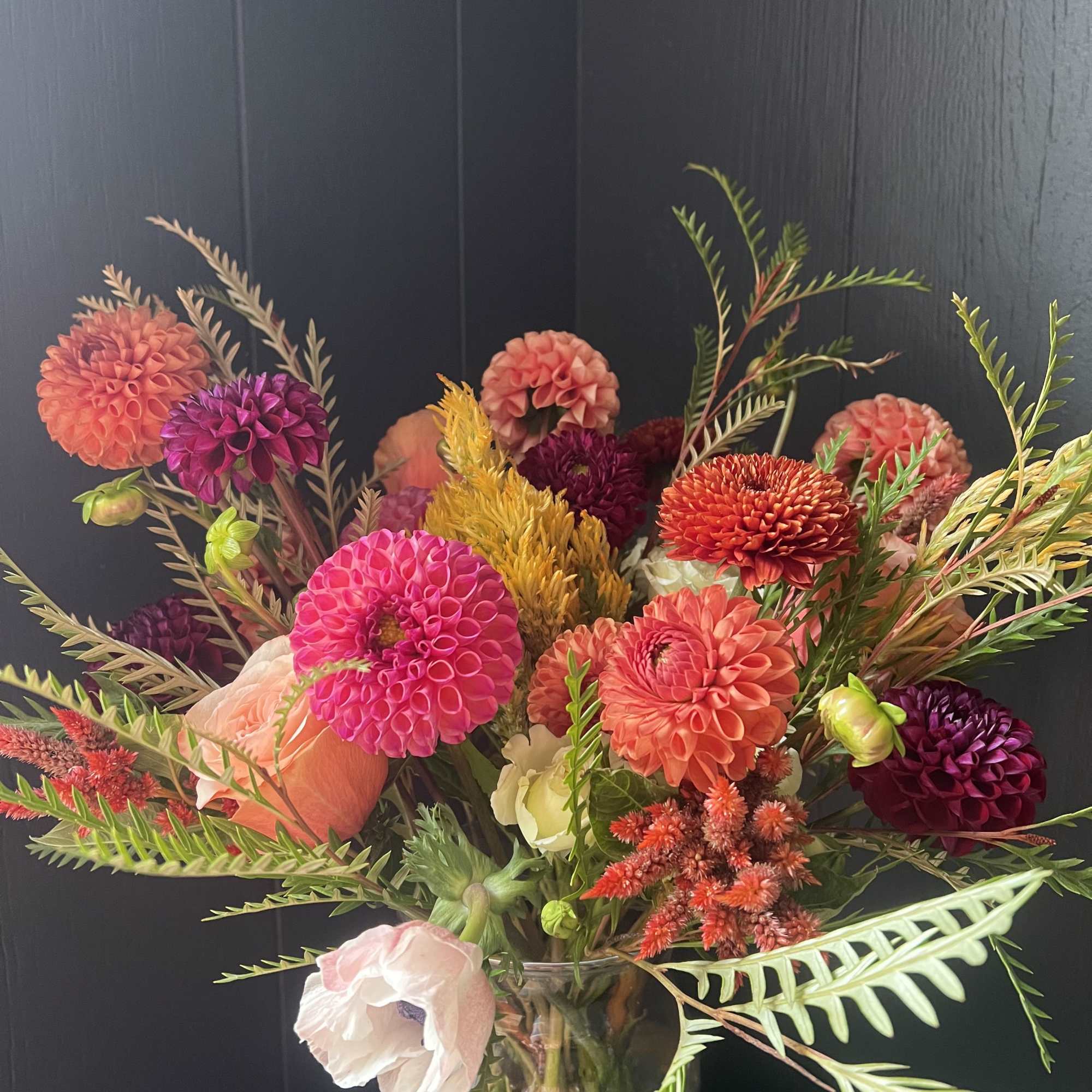 Bright mixed bouquet of dahlias in a glass vase