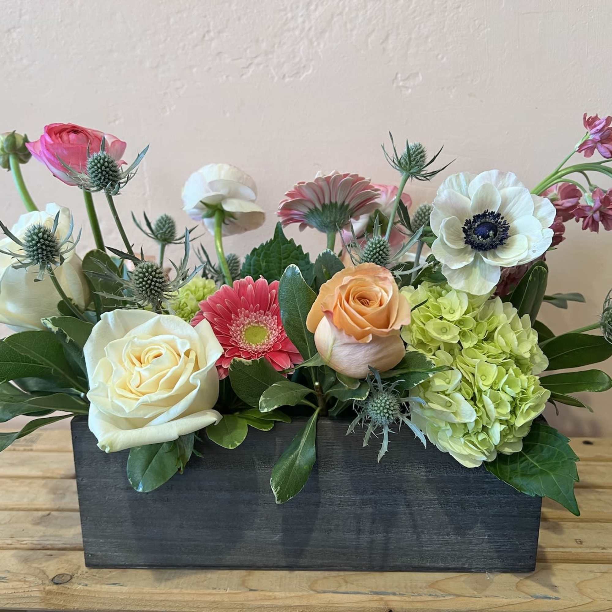 Mixed floral arrangement in a black rectangular box with roses and hydrangeas