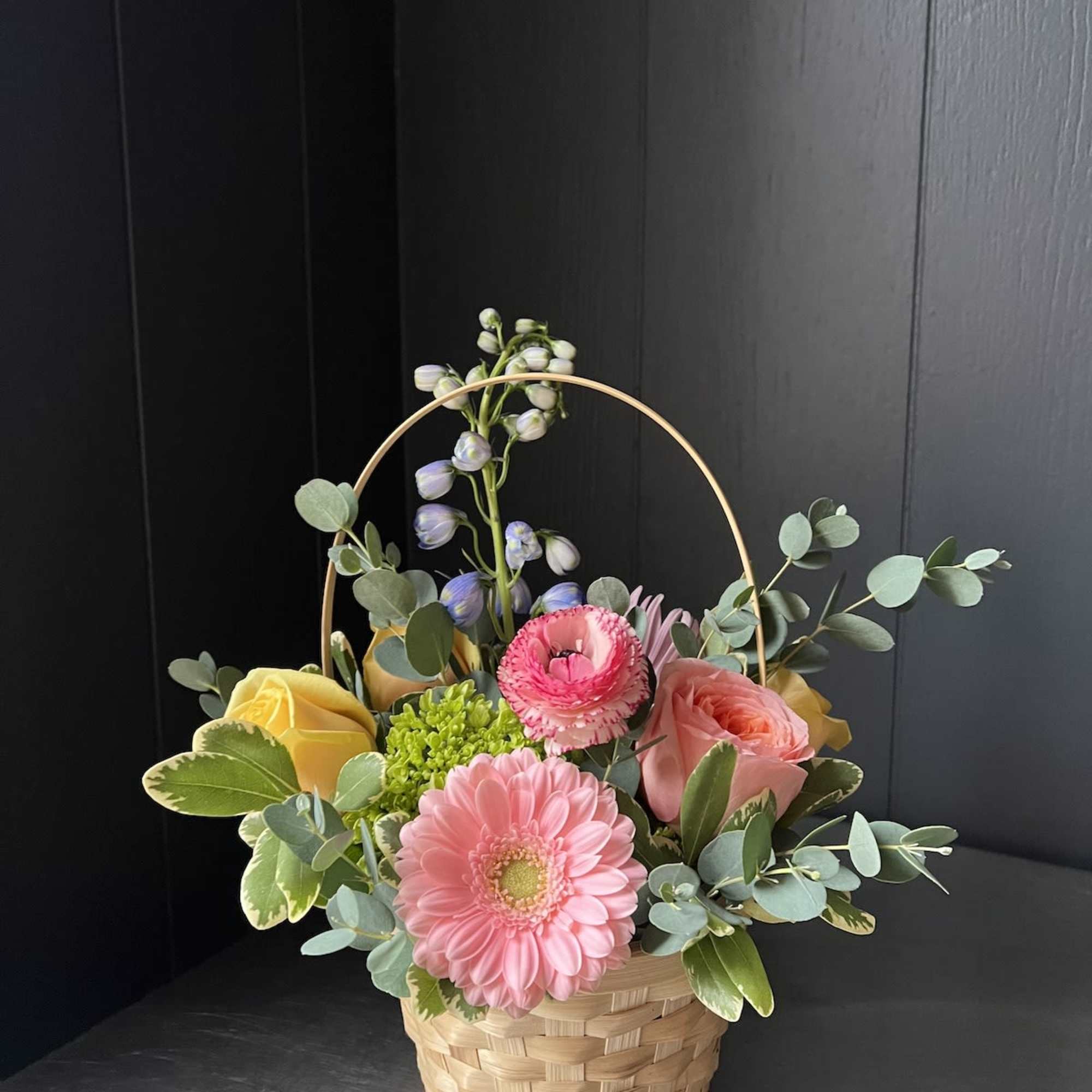 Seasonal, colorful flowers and foliage artfully arranged in circular woven basket.

Year round