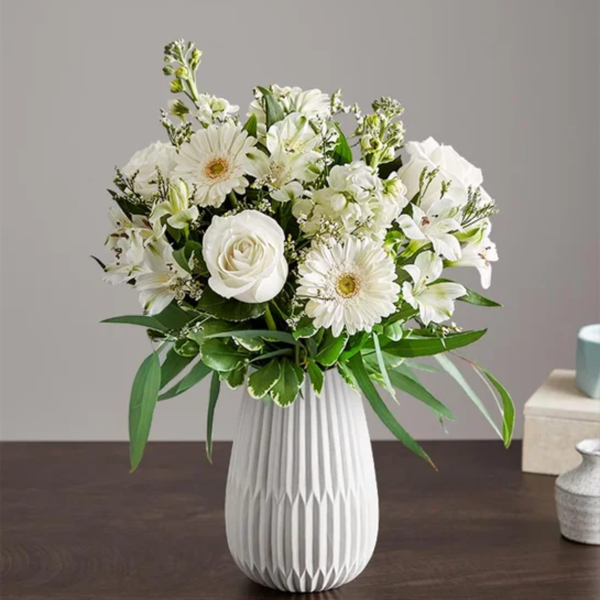 White flower bouquet in a ribbed white vase