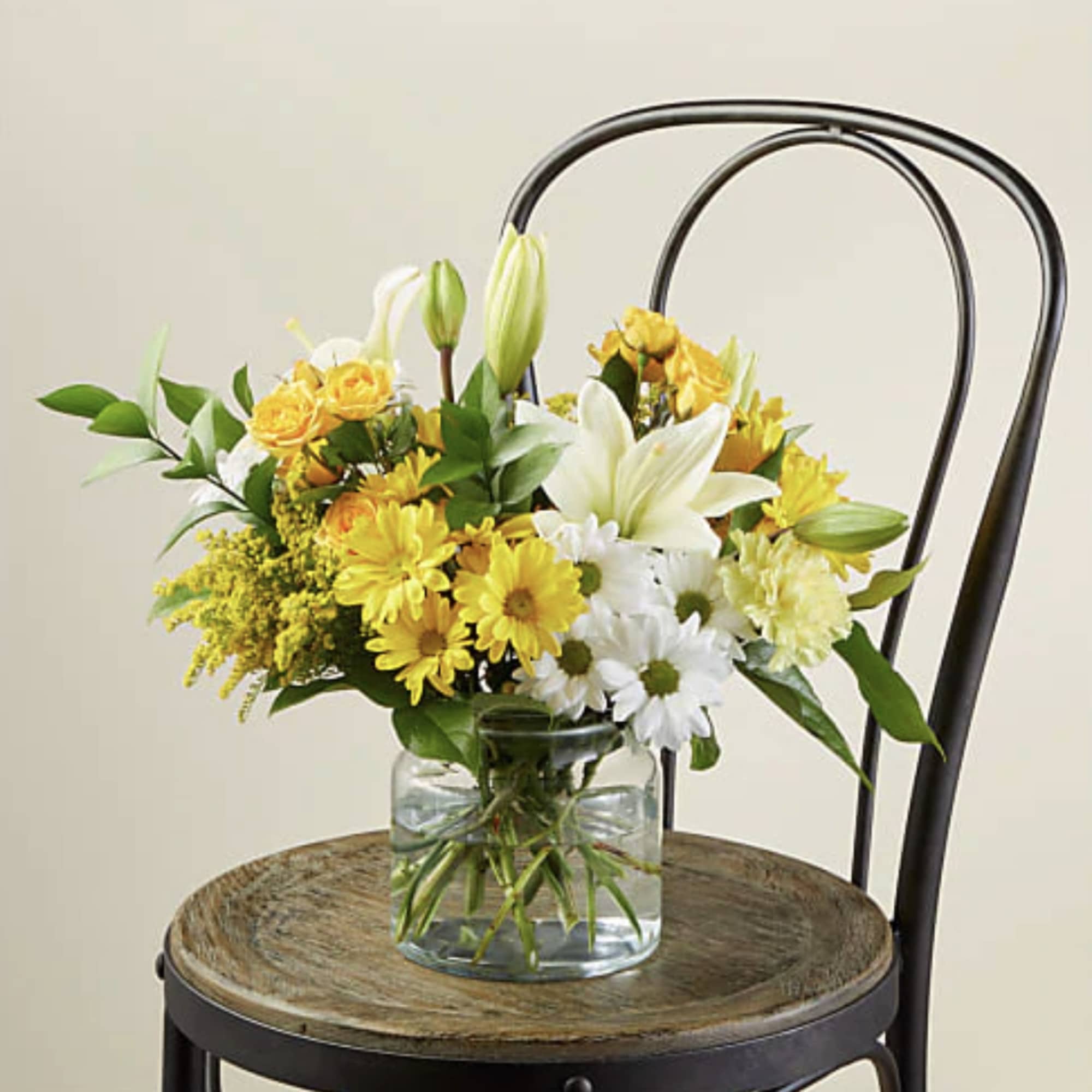 Yellow and white flower arrangement in a clear glass vase