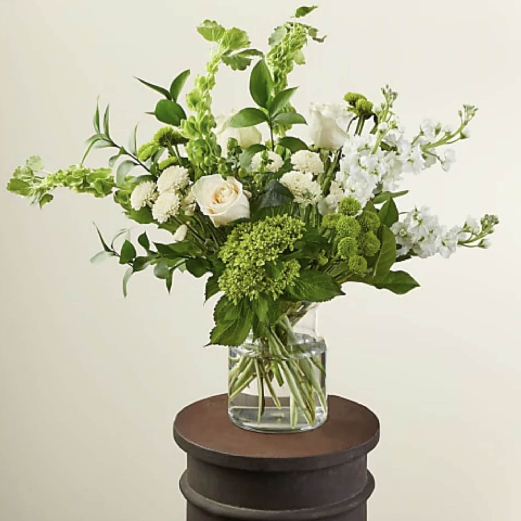 White and green floral arrangement in a clear glass vase