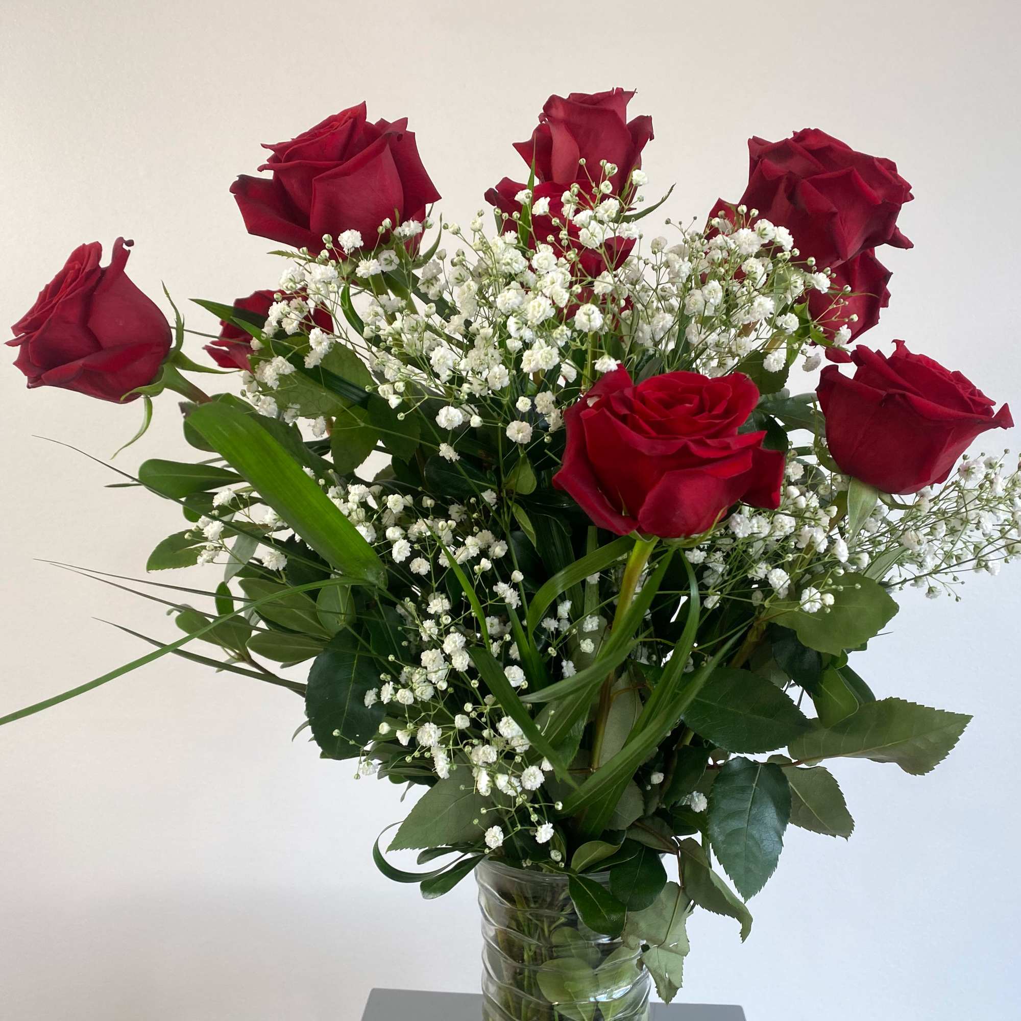 Bouquet of red roses with baby's breath in a glass vase