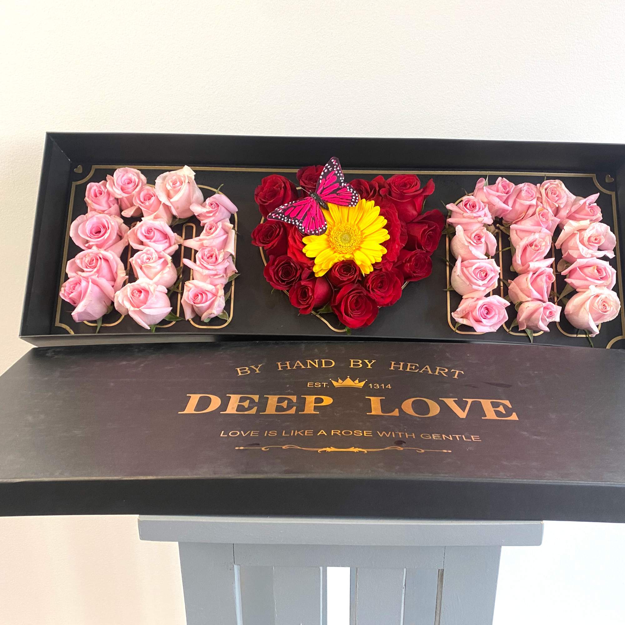 Gift box with pink and red roses and a yellow flower centerpiece