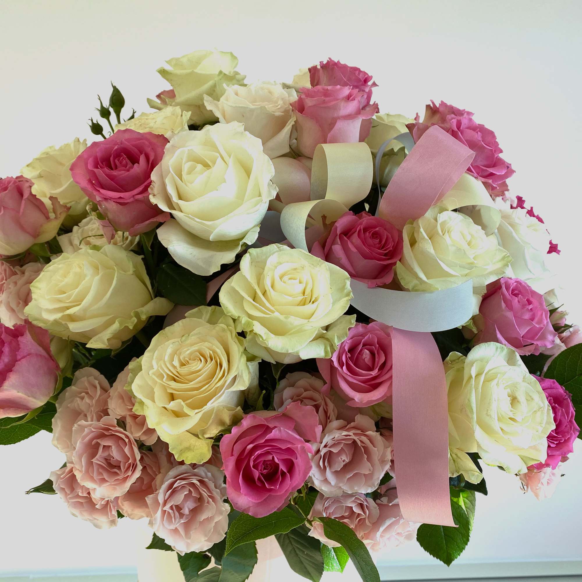 Bouquet of pink and white roses with ribbon accents