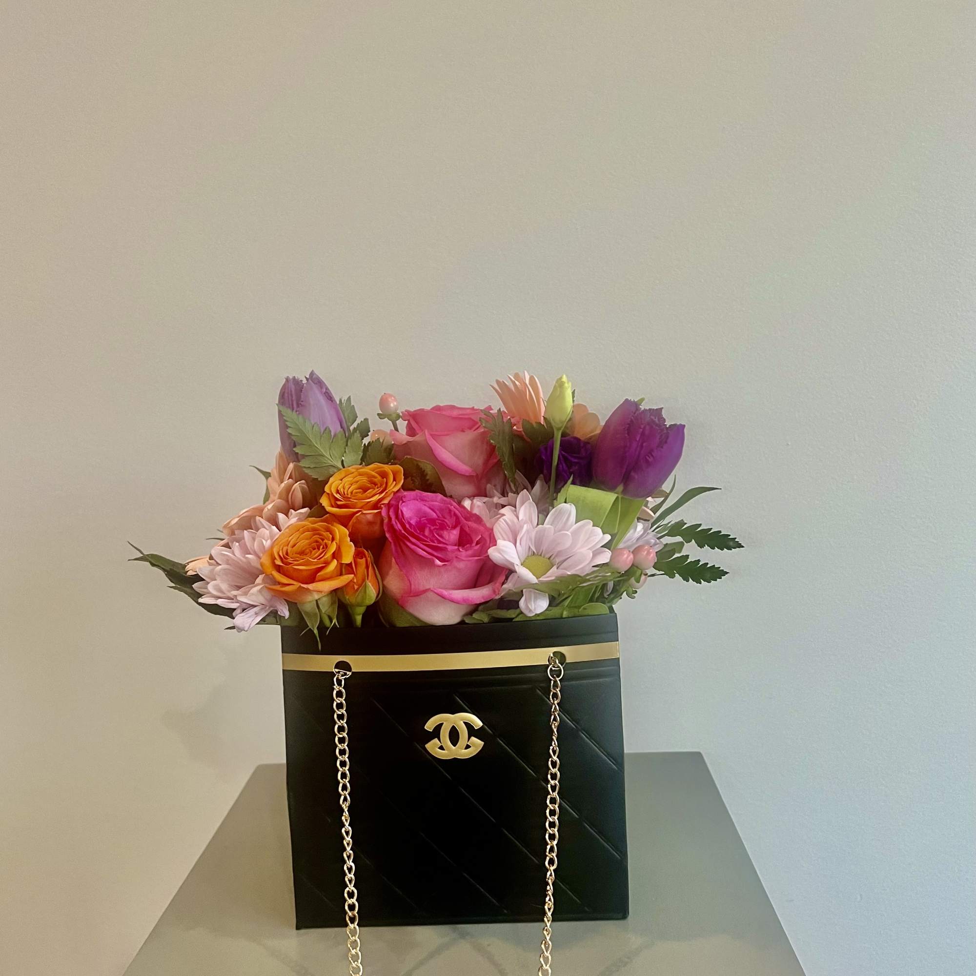 Mixed bouquet in a black box purse with gold chain handles