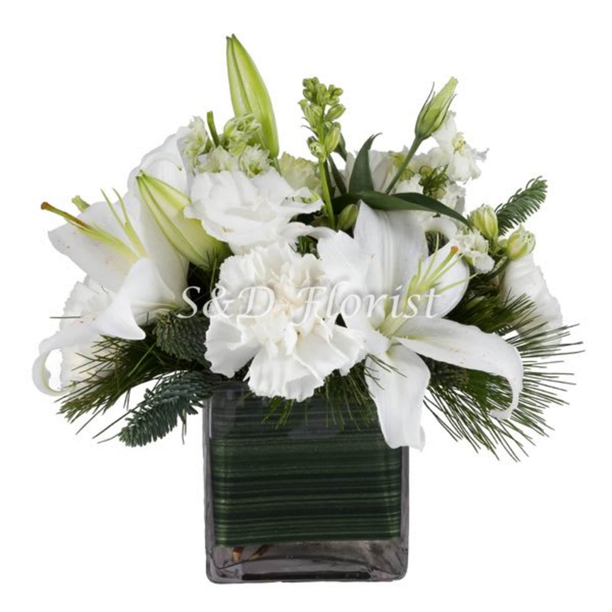 White lilies and carnations arranged in a dark square vase