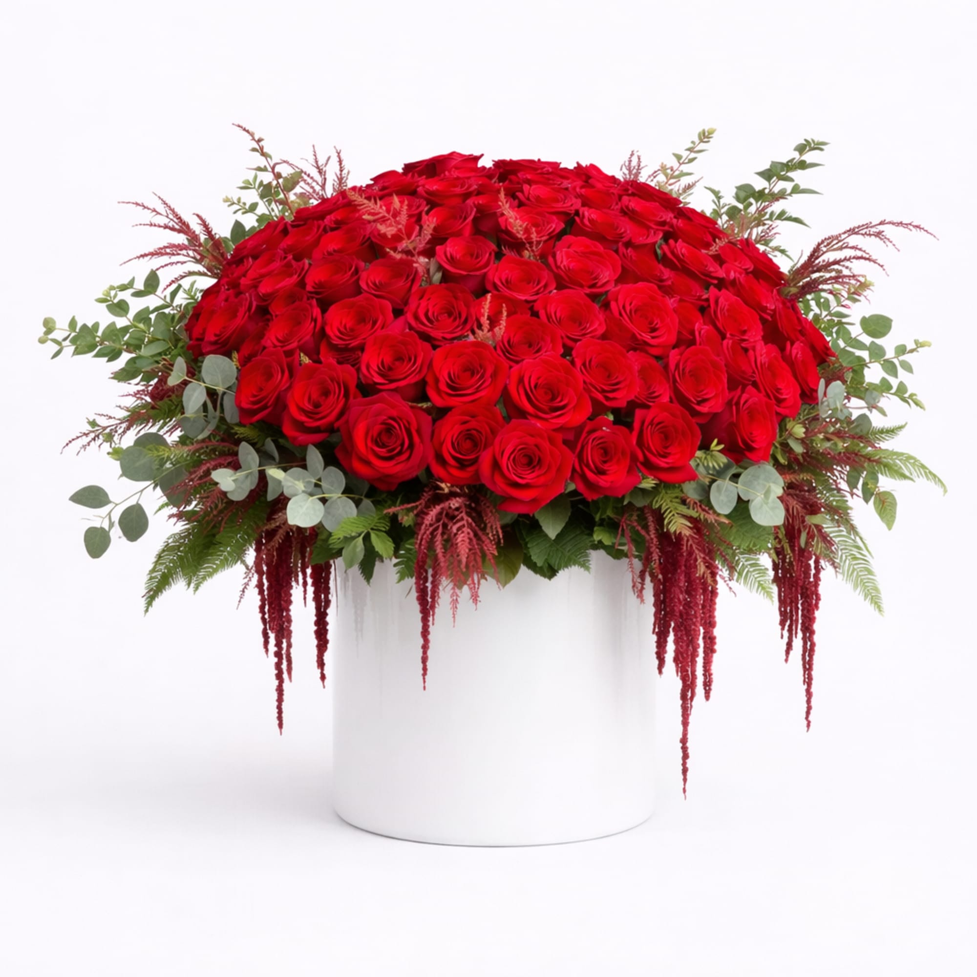 Large red rose arrangement in a white cylindrical vase