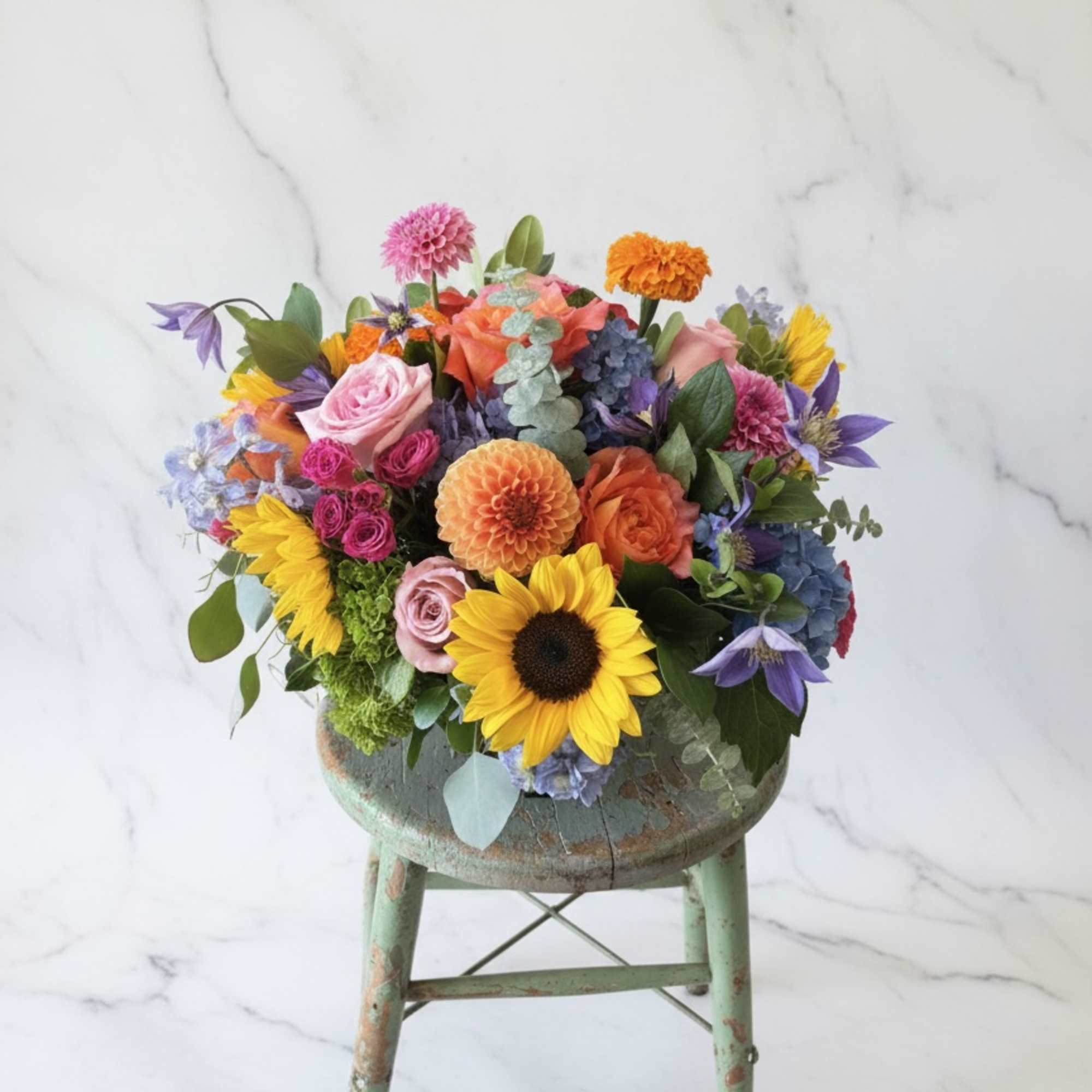 Colorful mixed bouquet in a rustic stool-style container