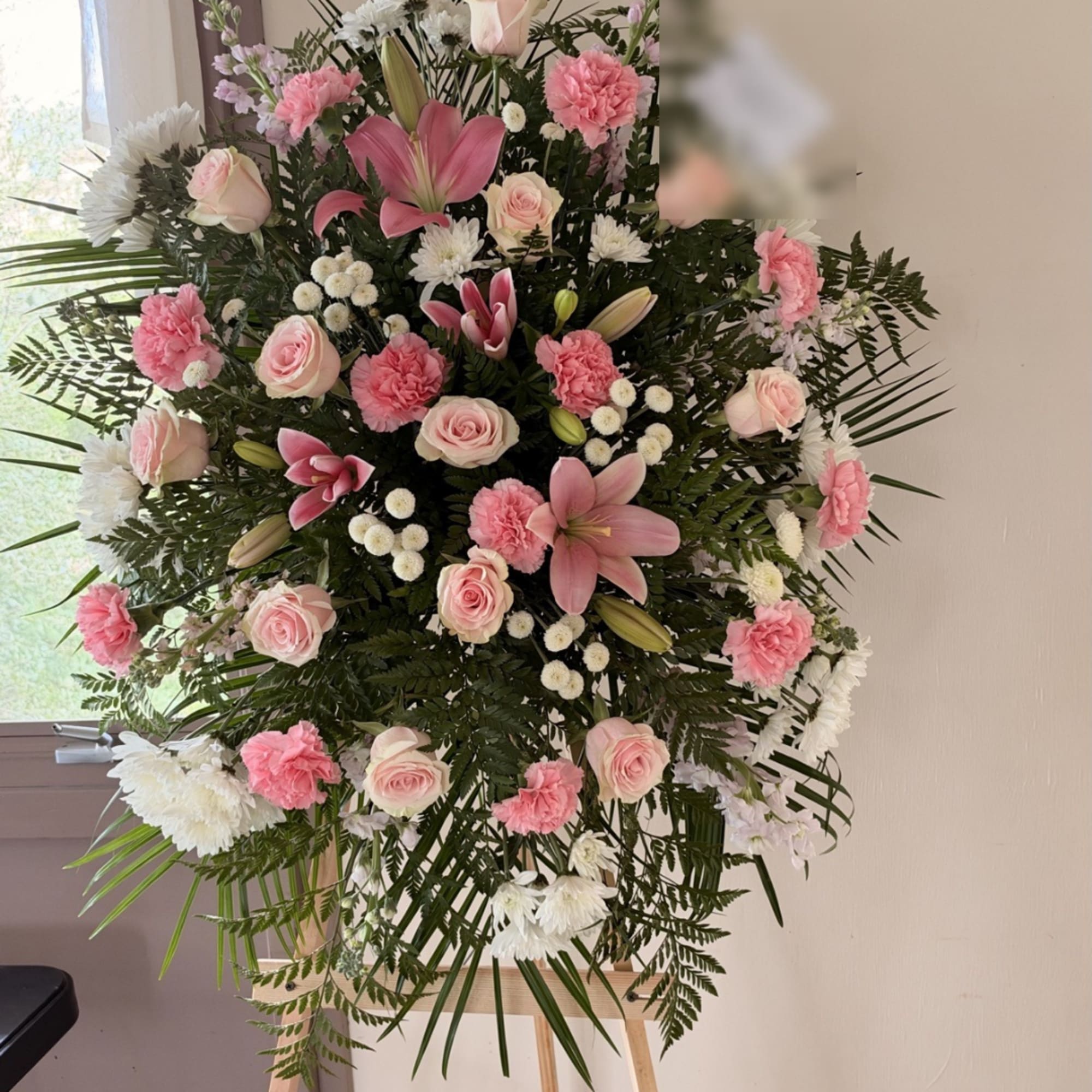 Pink and white floral standing spray with roses, lilies, and carnations