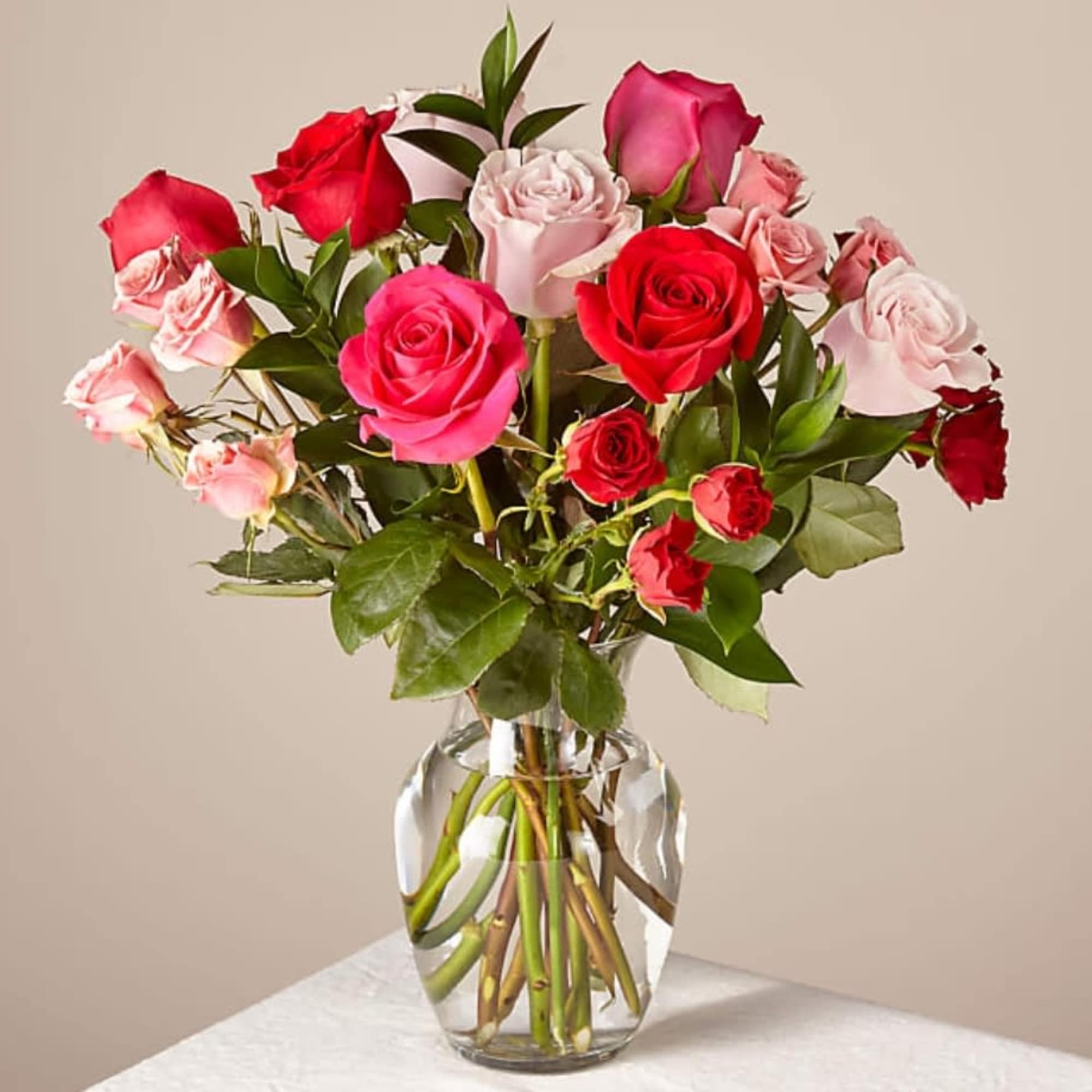 Bouquet of red and pink roses arranged in a clear glass vase