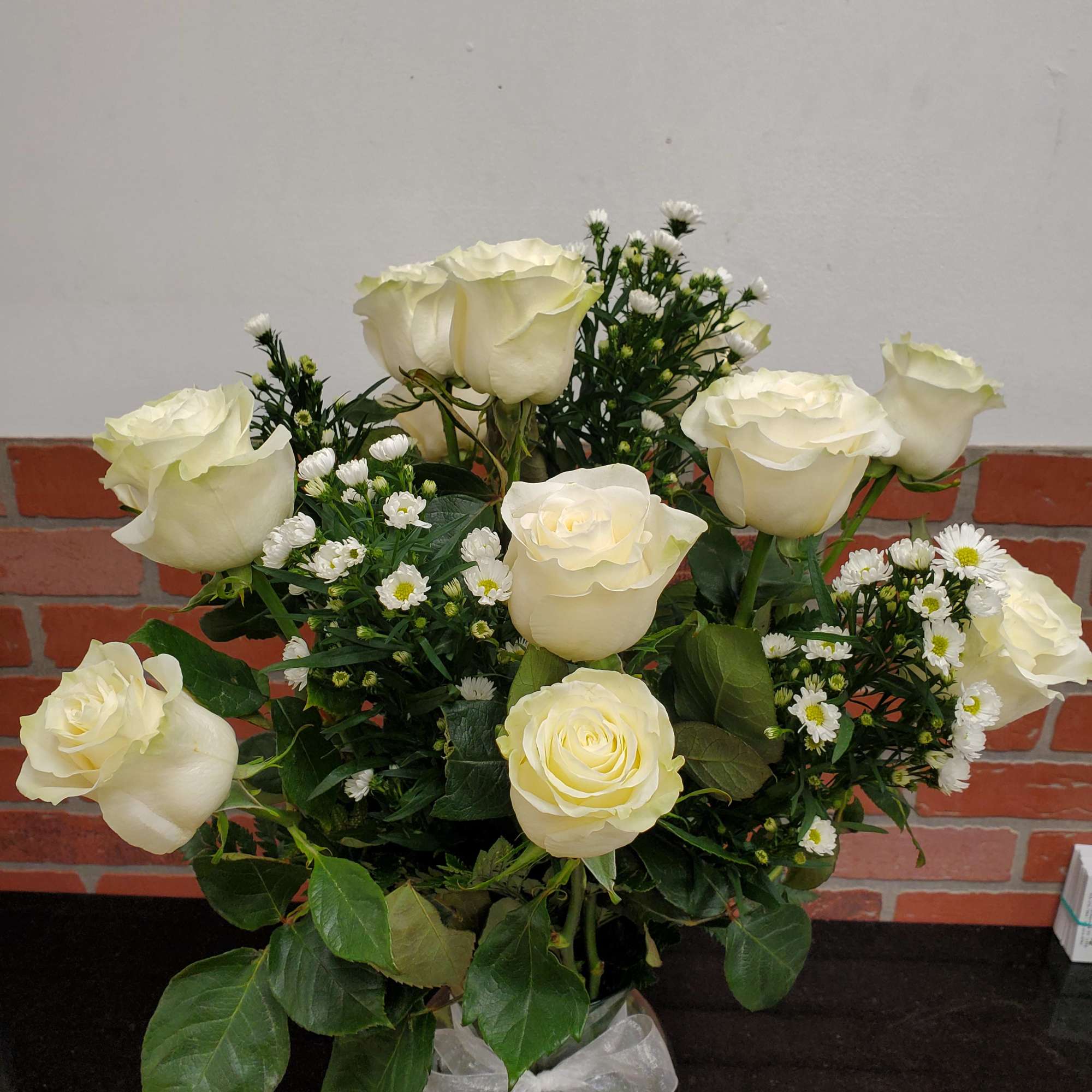 12 white roses in a nice clear vase with white monte casino
