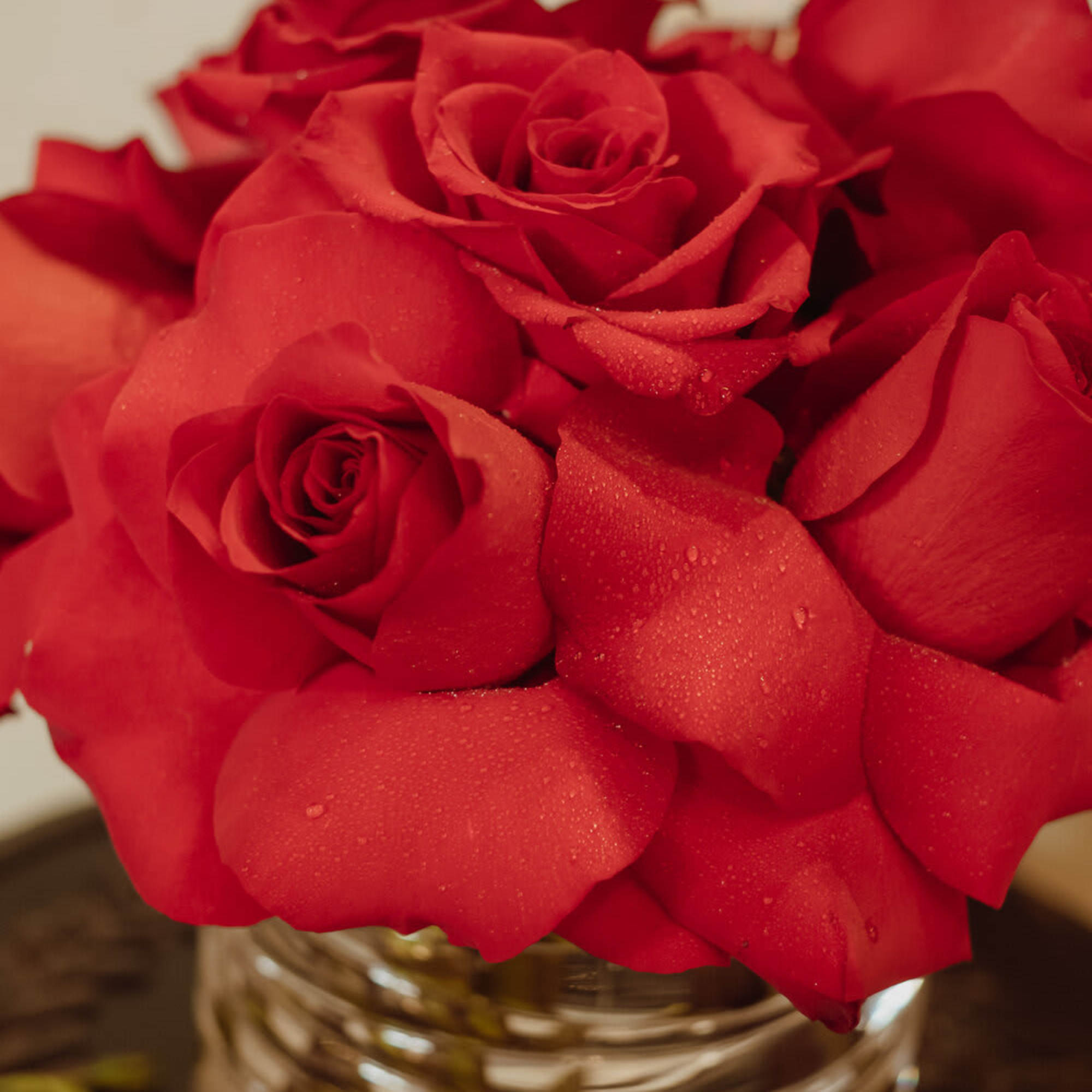 Red roses arranged in a clear glass vase, photo 2 of 3