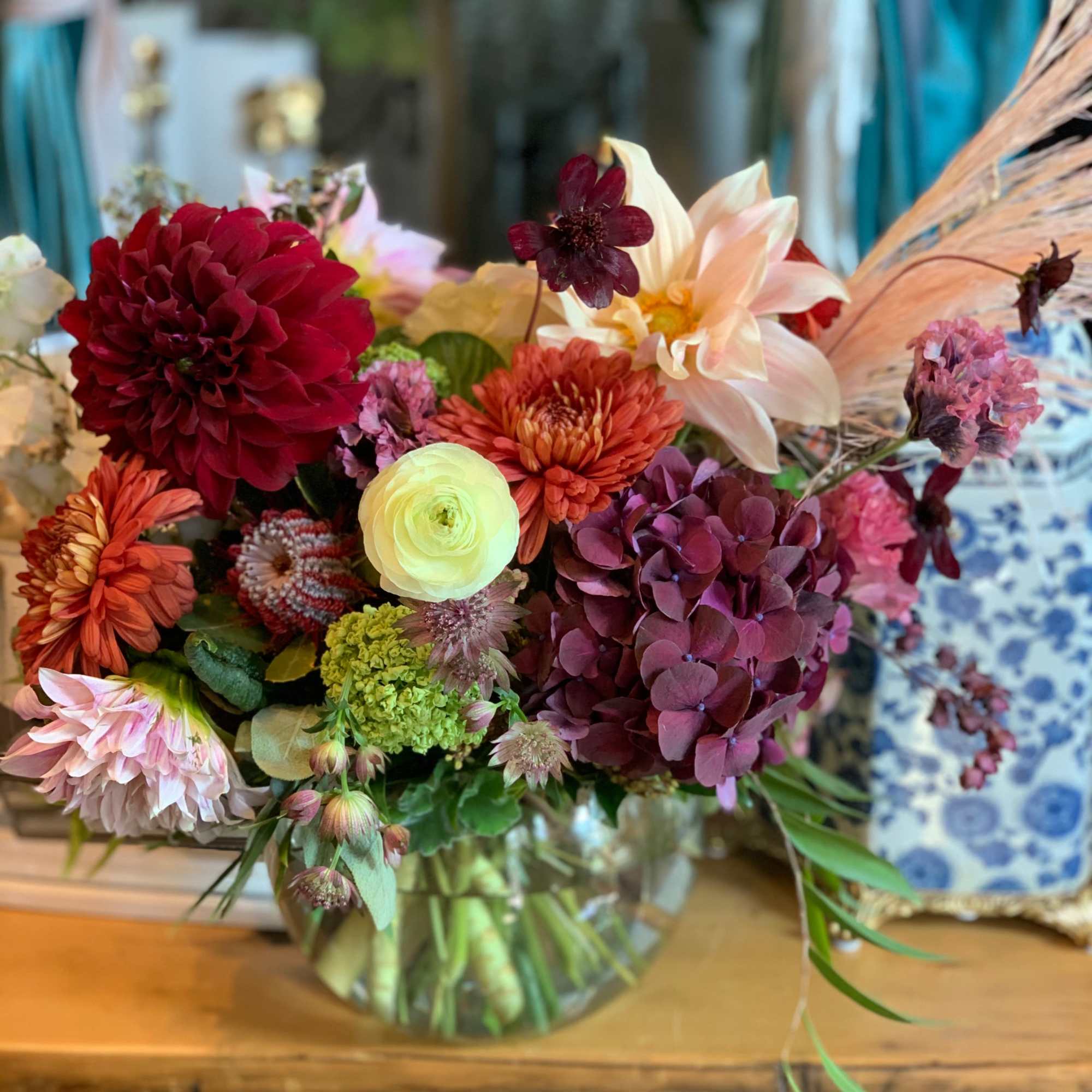 Mixed bouquet in a glass vase with burgundy, peach, and cream blooms
