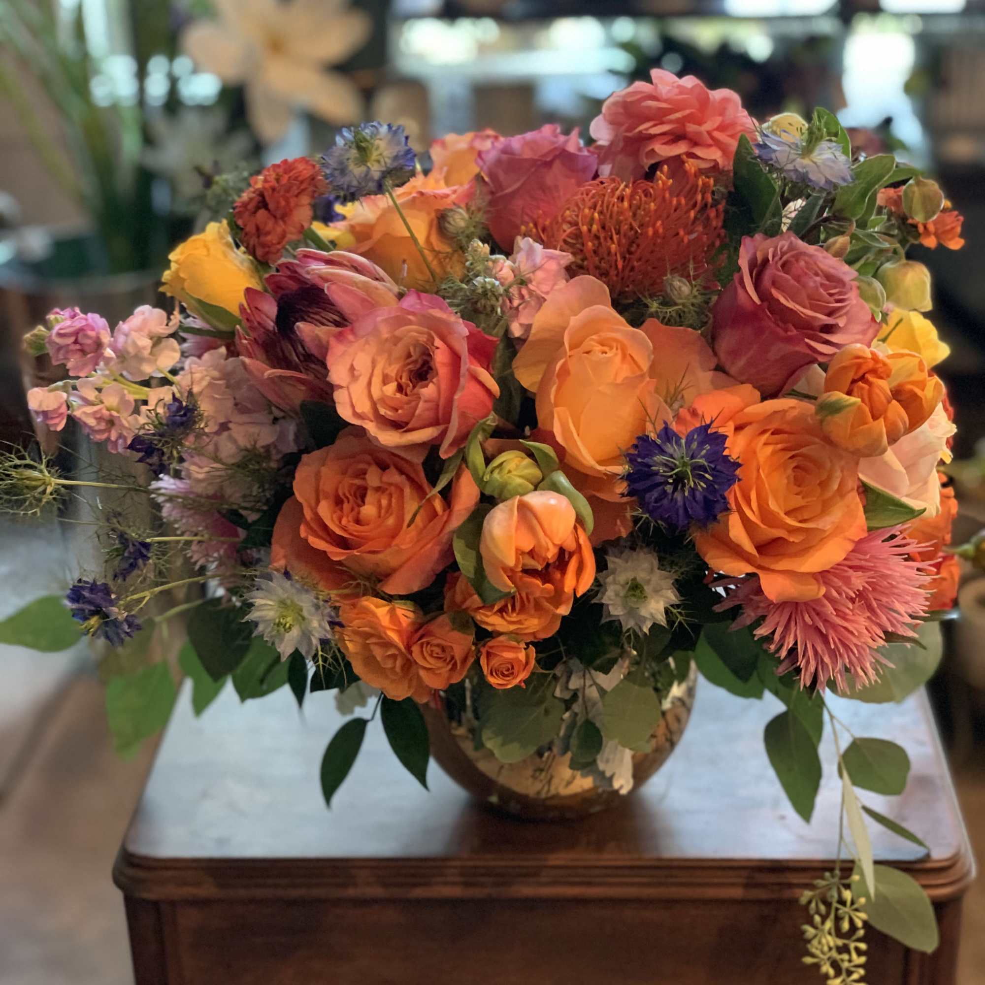 Mixed bouquet of orange, pink, and purple flowers in a vase