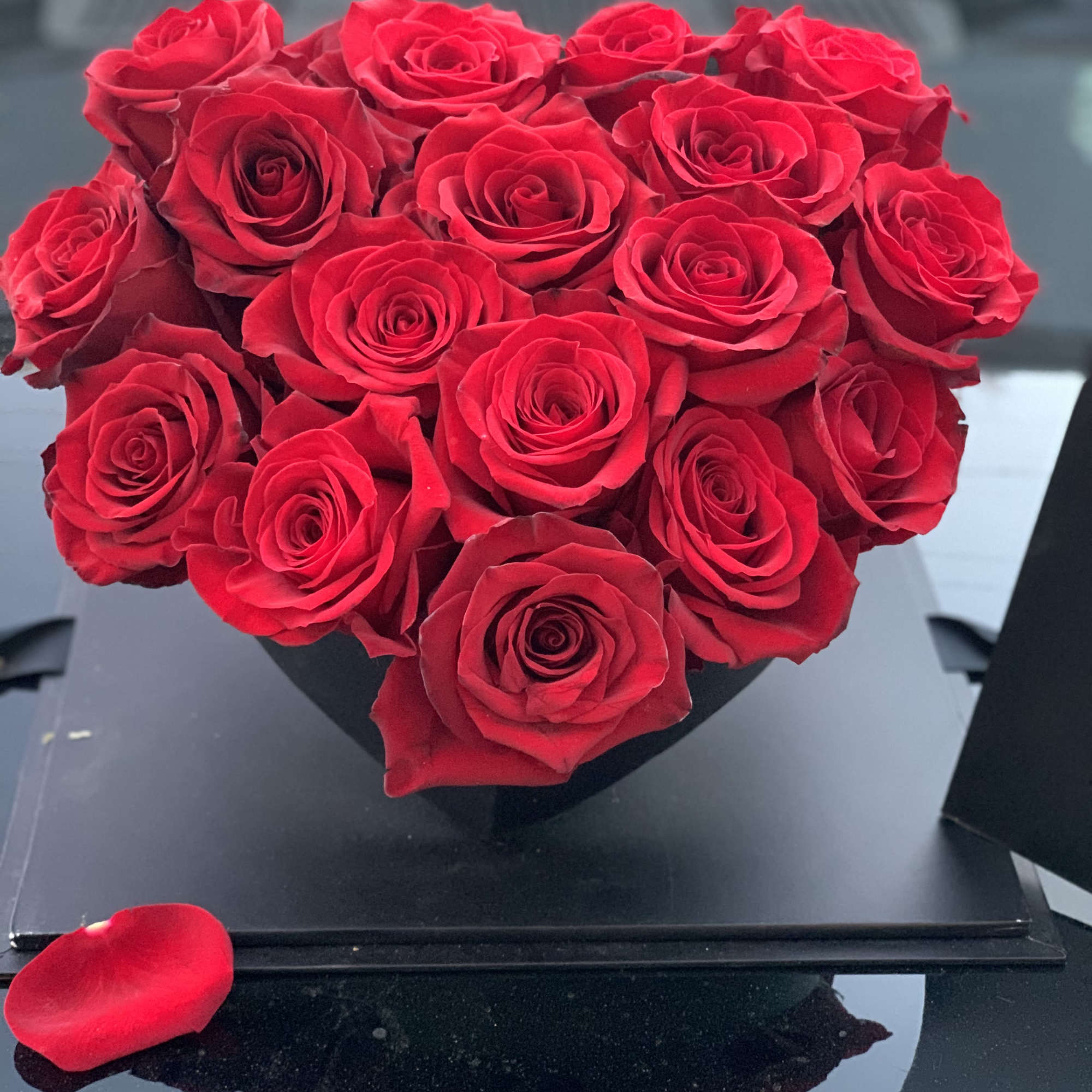 Heart-shaped bouquet of red roses in a black box