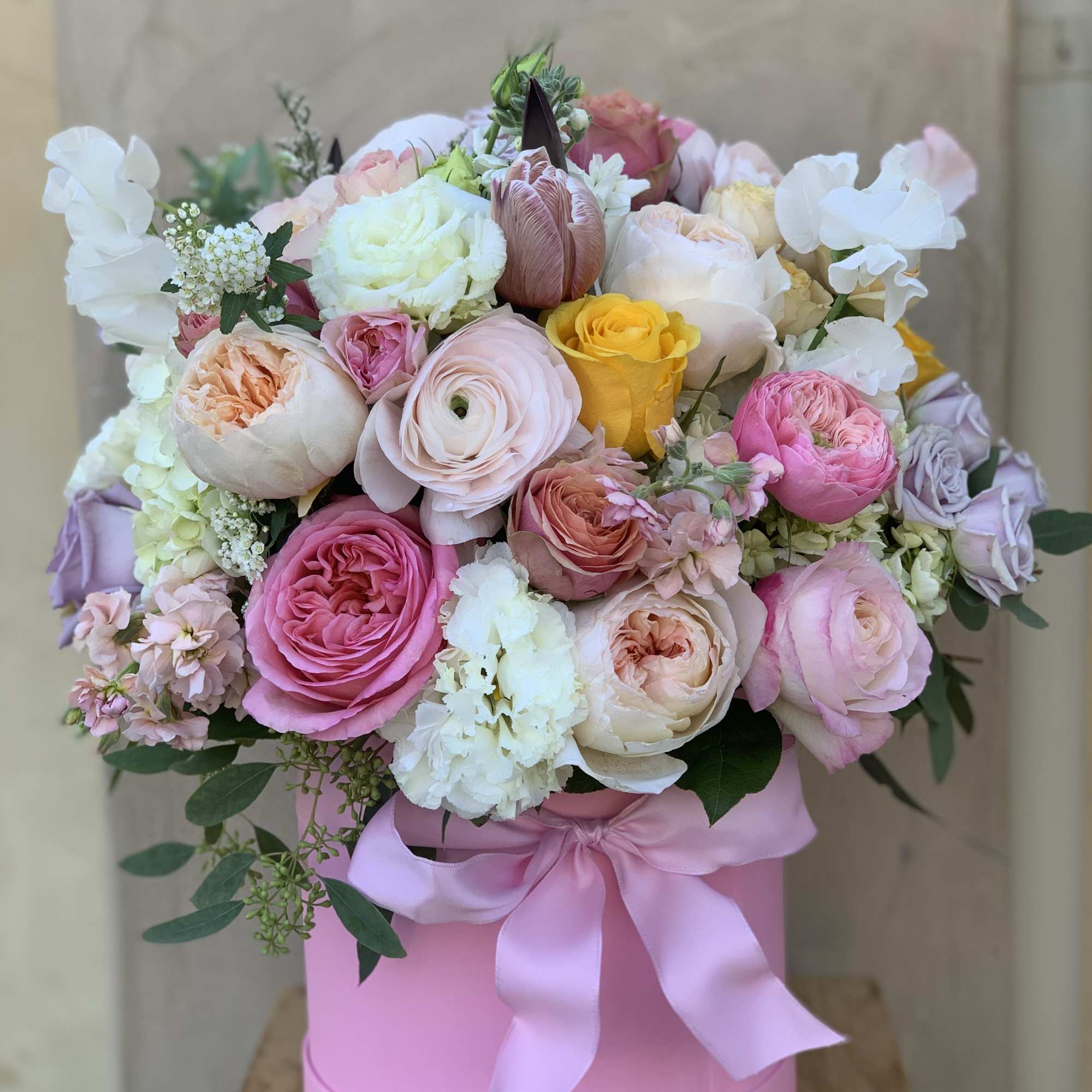 Pink and white rose bouquet in a pink hat box with a satin ribbon