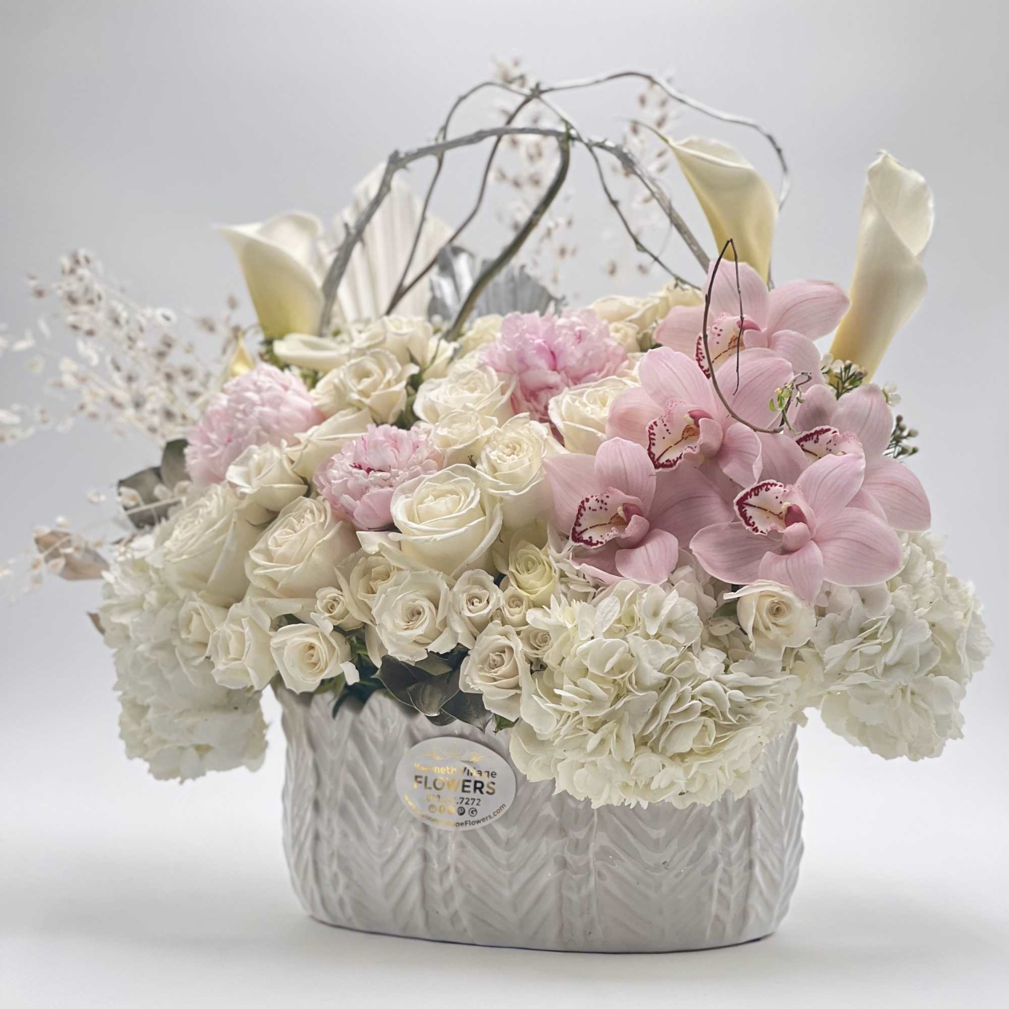 White roses and pink orchids in a silver vase arrangement