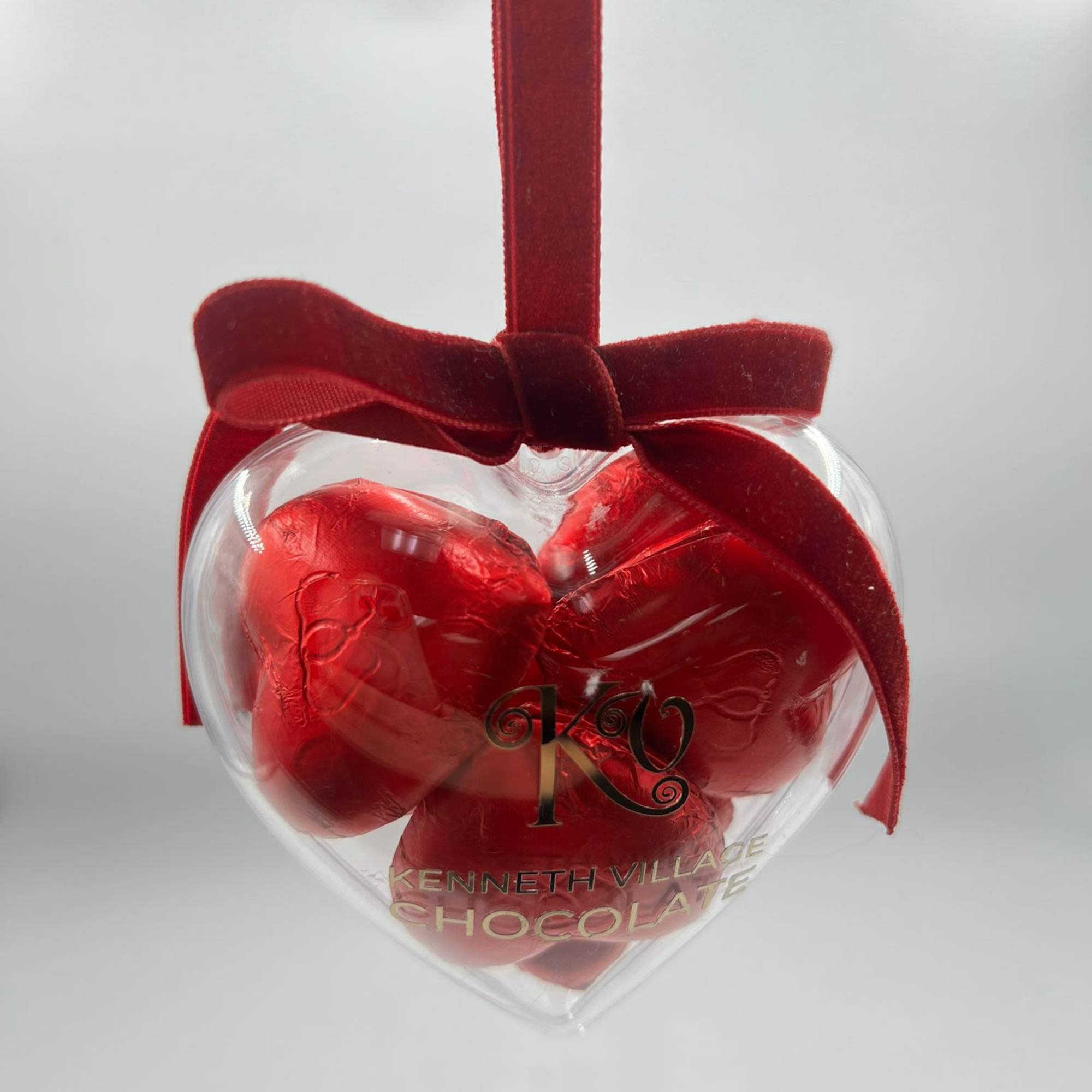 Heart-shaped chocolate gift box with a red ribbon bow