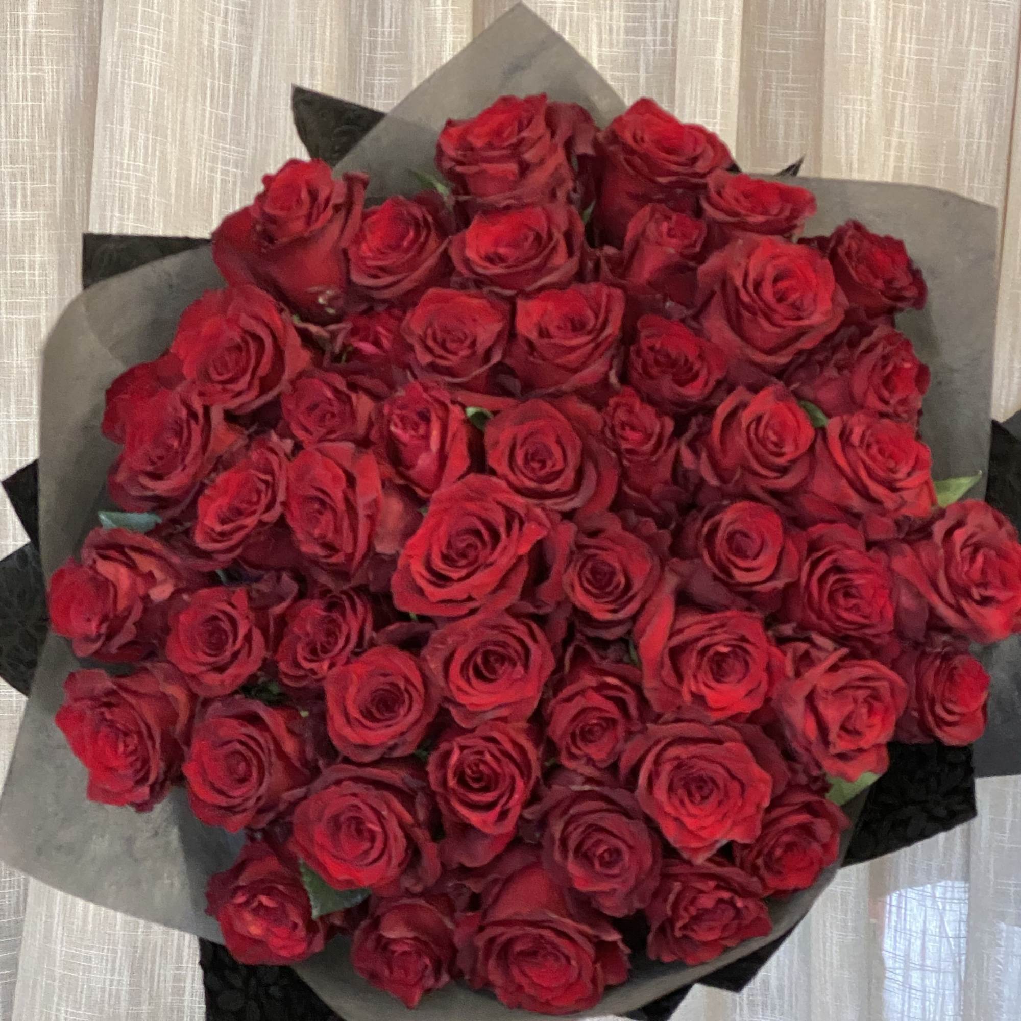 Large bouquet of red roses wrapped in gray and black paper