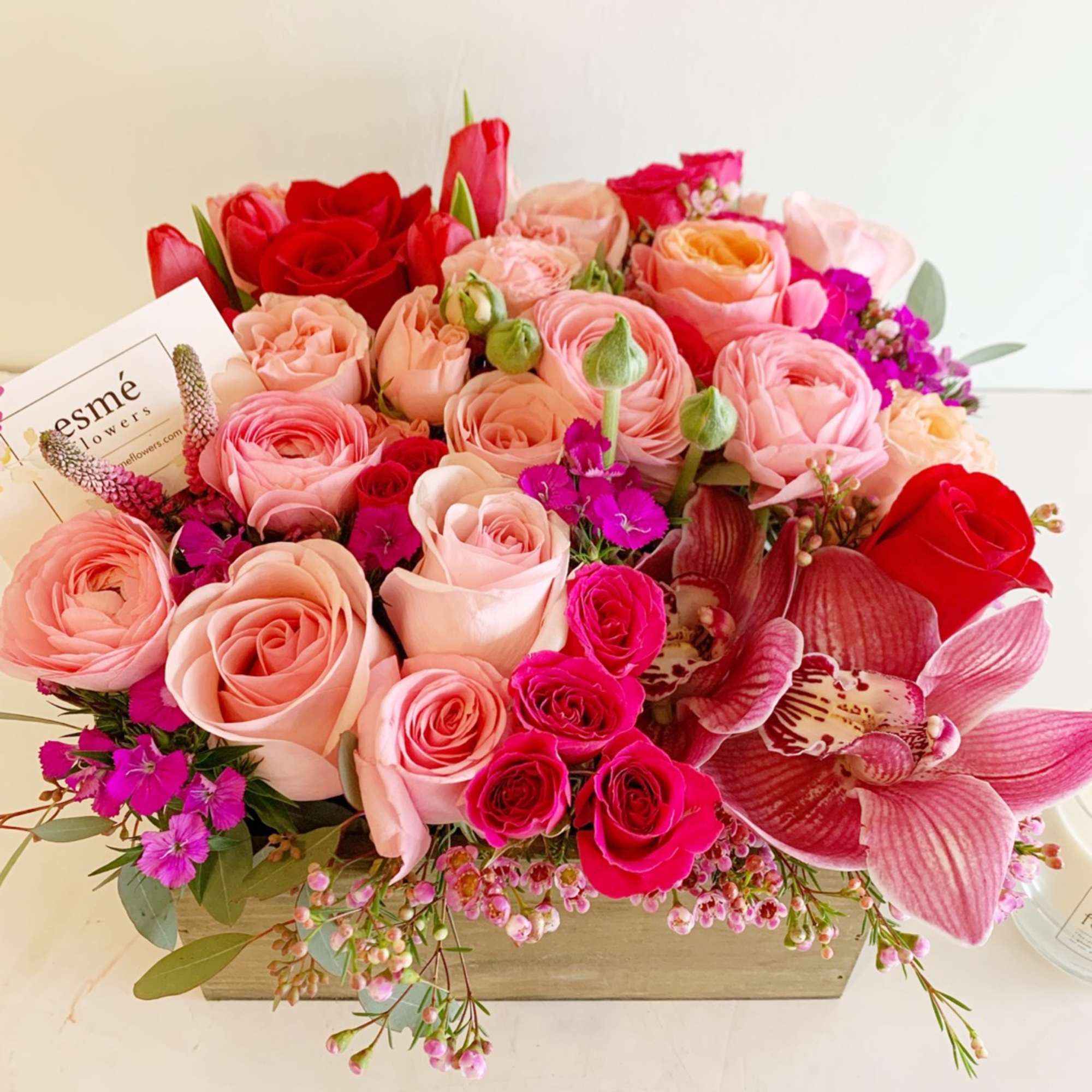 Pink and red rose bouquet with orchids in a wooden box