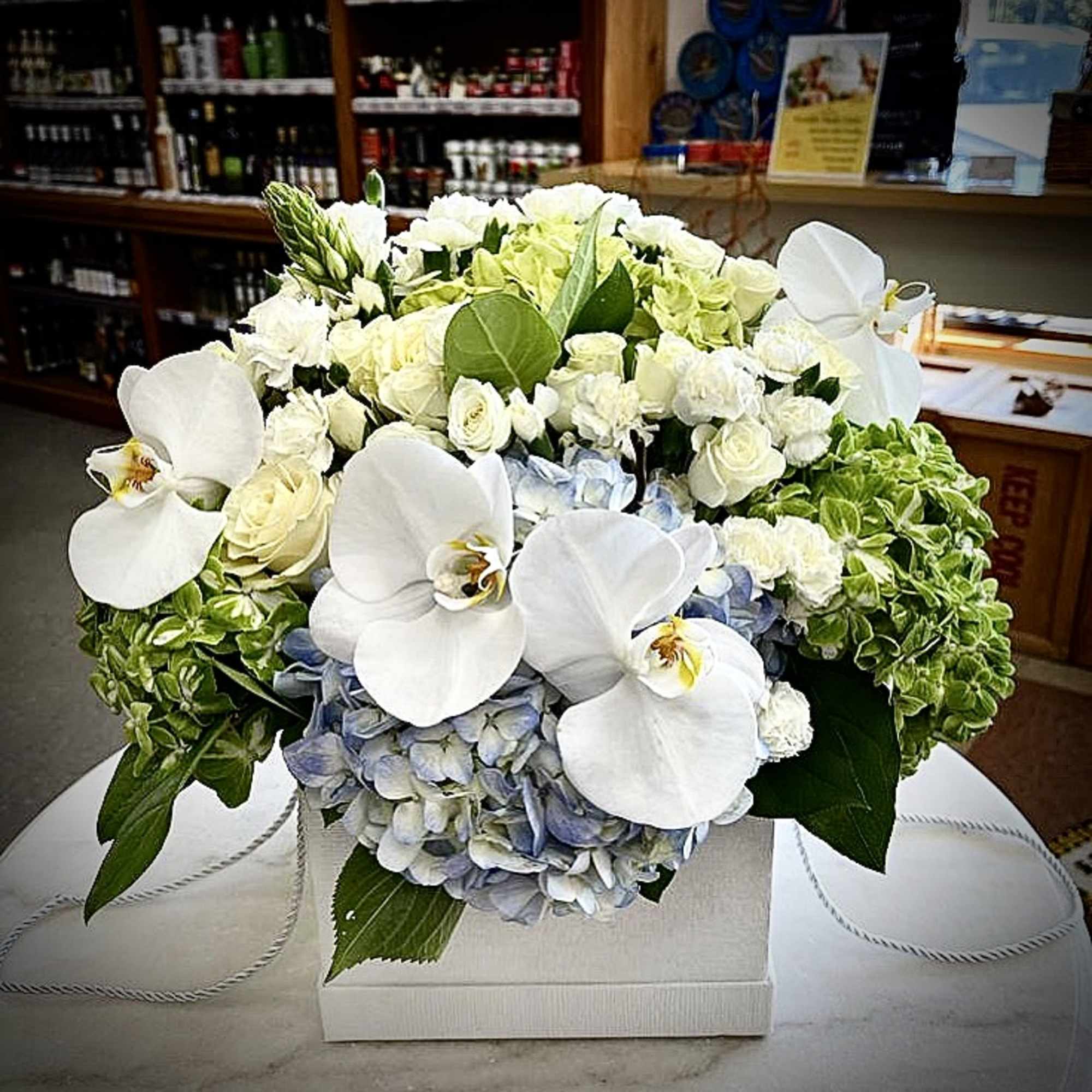 White orchids and hydrangeas in a low box arrangement