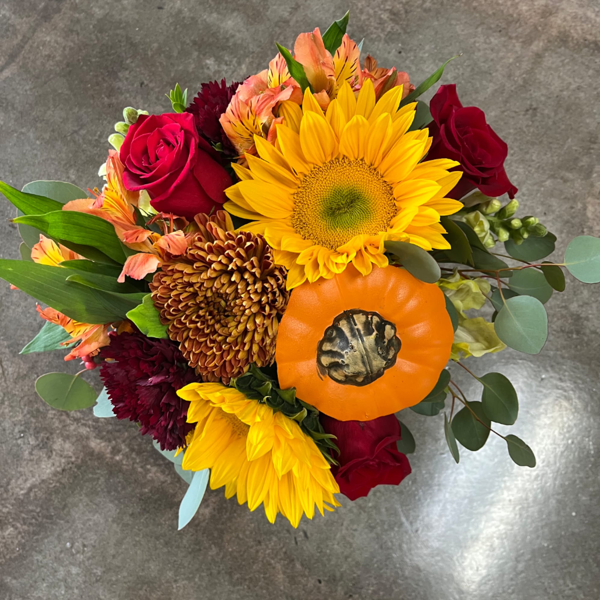 Bouquet with sunflowers, red roses, and an orange pumpkin accent