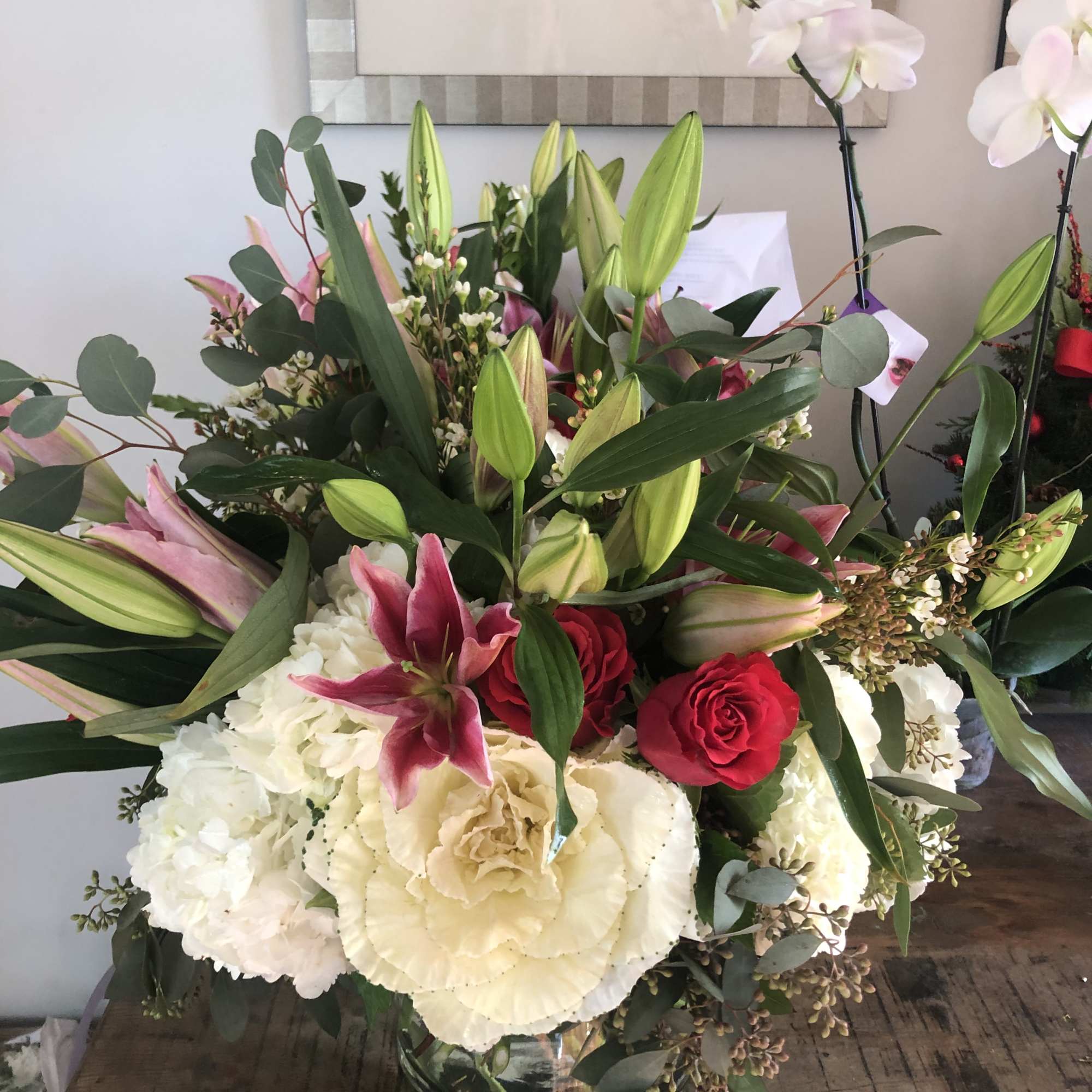 Large bouquet of lilies, roses, hydrangeas, and orchids in a glass vase