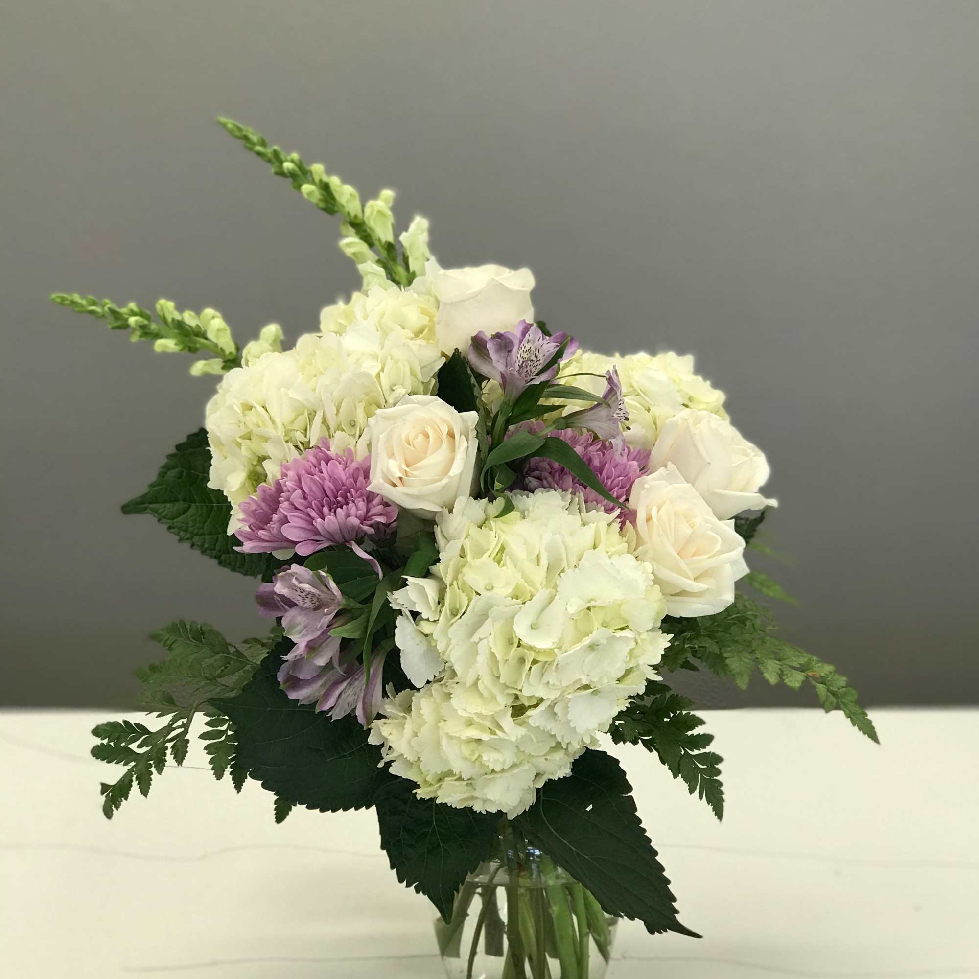 Bouquet of white and lavender flowers in a clear glass vase