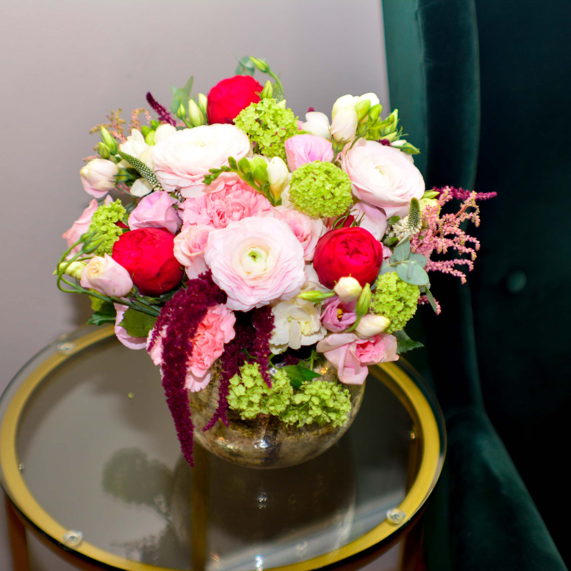 Mixed pink and white flowers arranged in a round glass vase