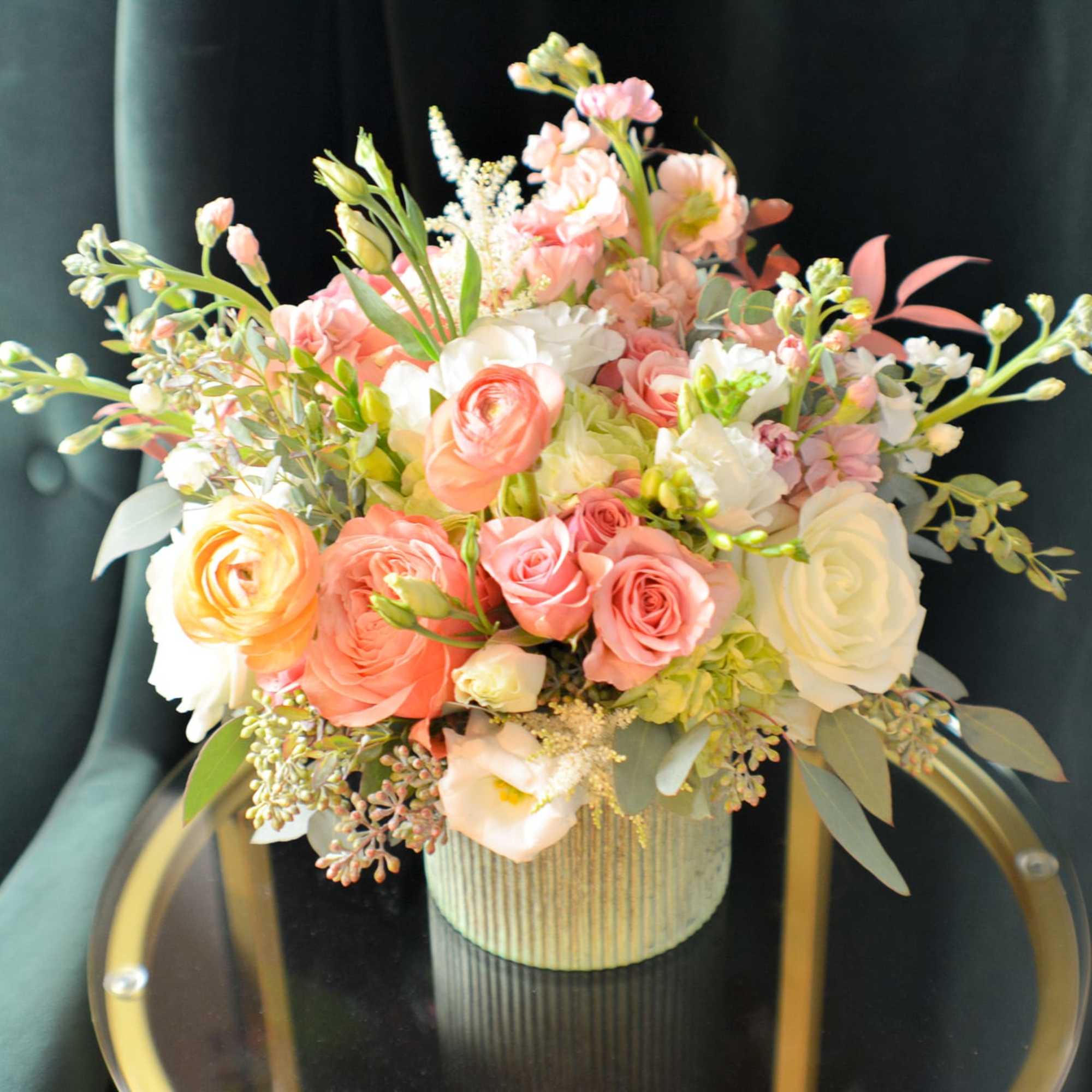 Pink and white rose arrangement in a ribbed vase
