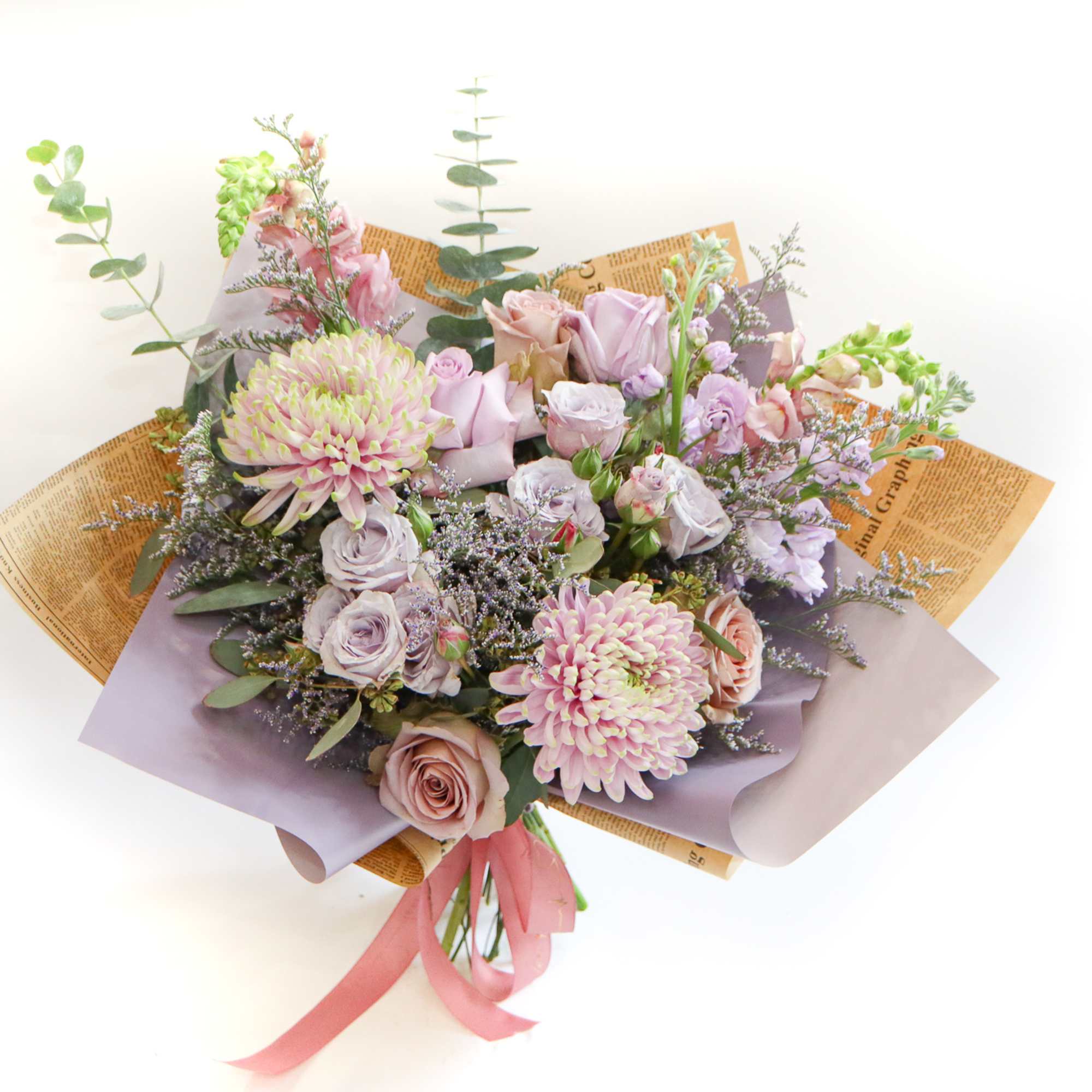 Bouquet of pastel roses and chrysanthemums wrapped in lavender paper