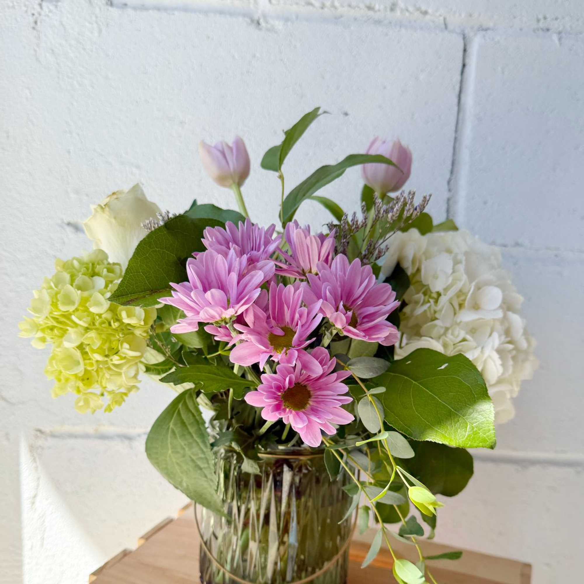 Pink daisies and hydrangeas in a glass vase