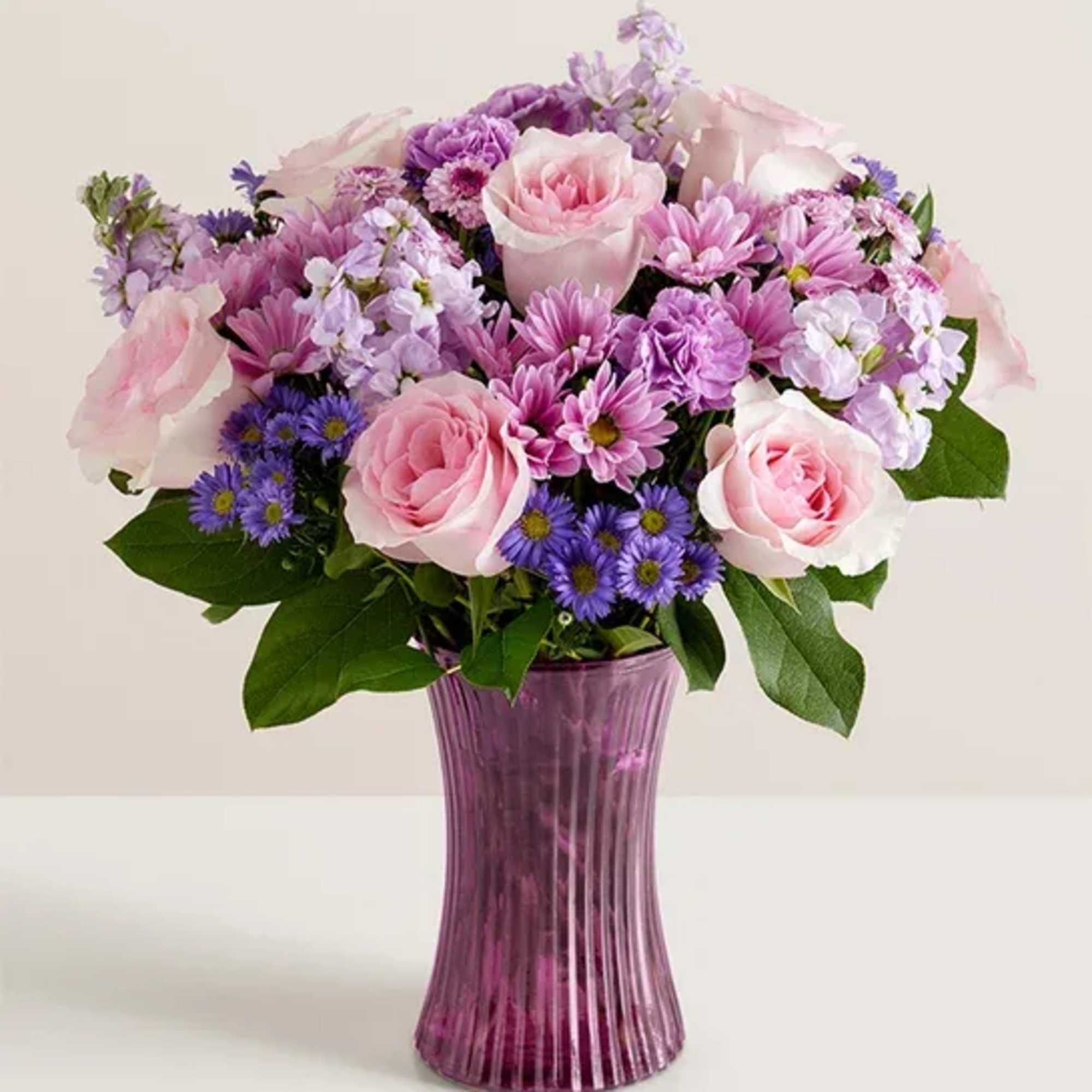 Pink and purple bouquet in a tall purple vase