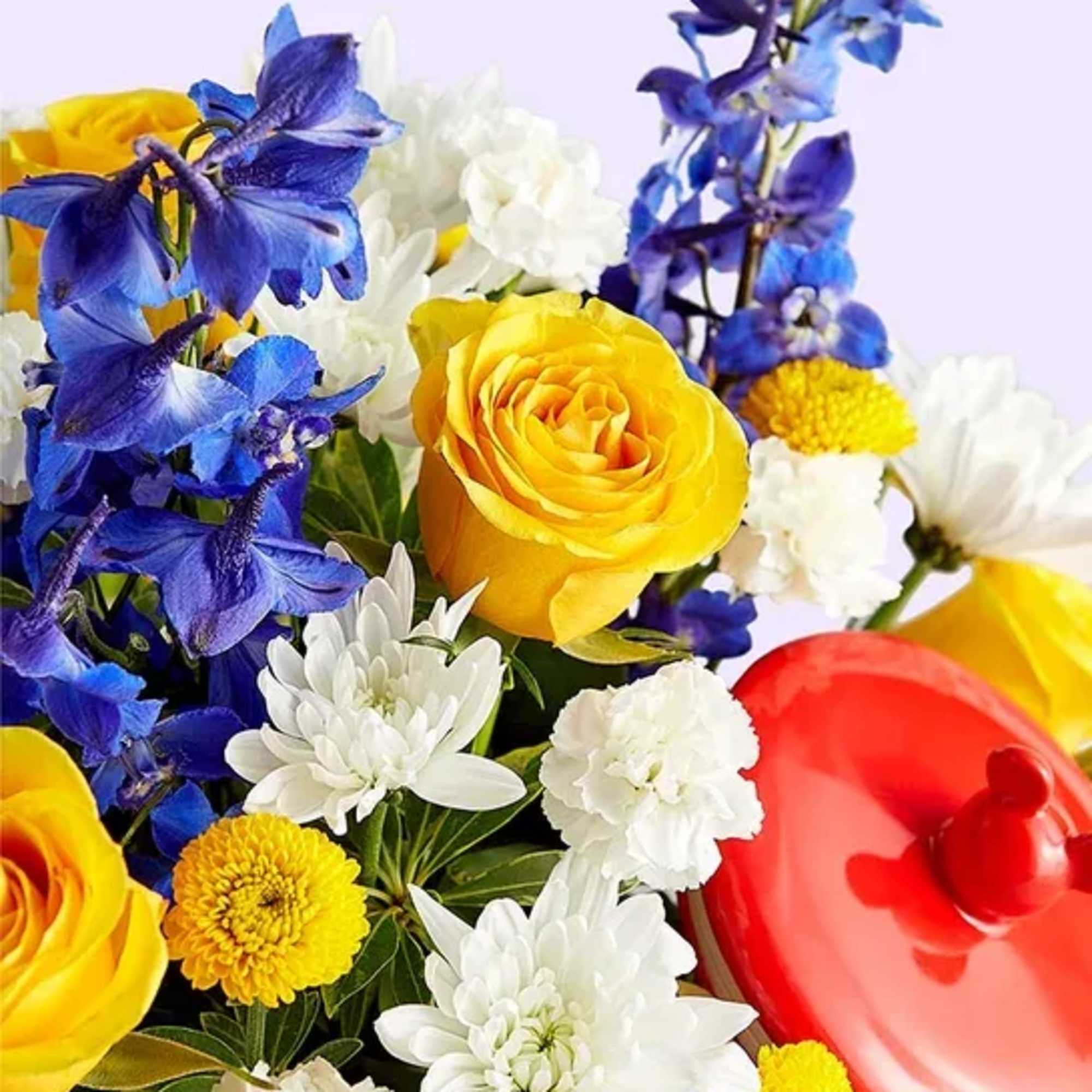 Bouquet of yellow roses, blue flowers, and white daisies with a red heart-shaped balloon