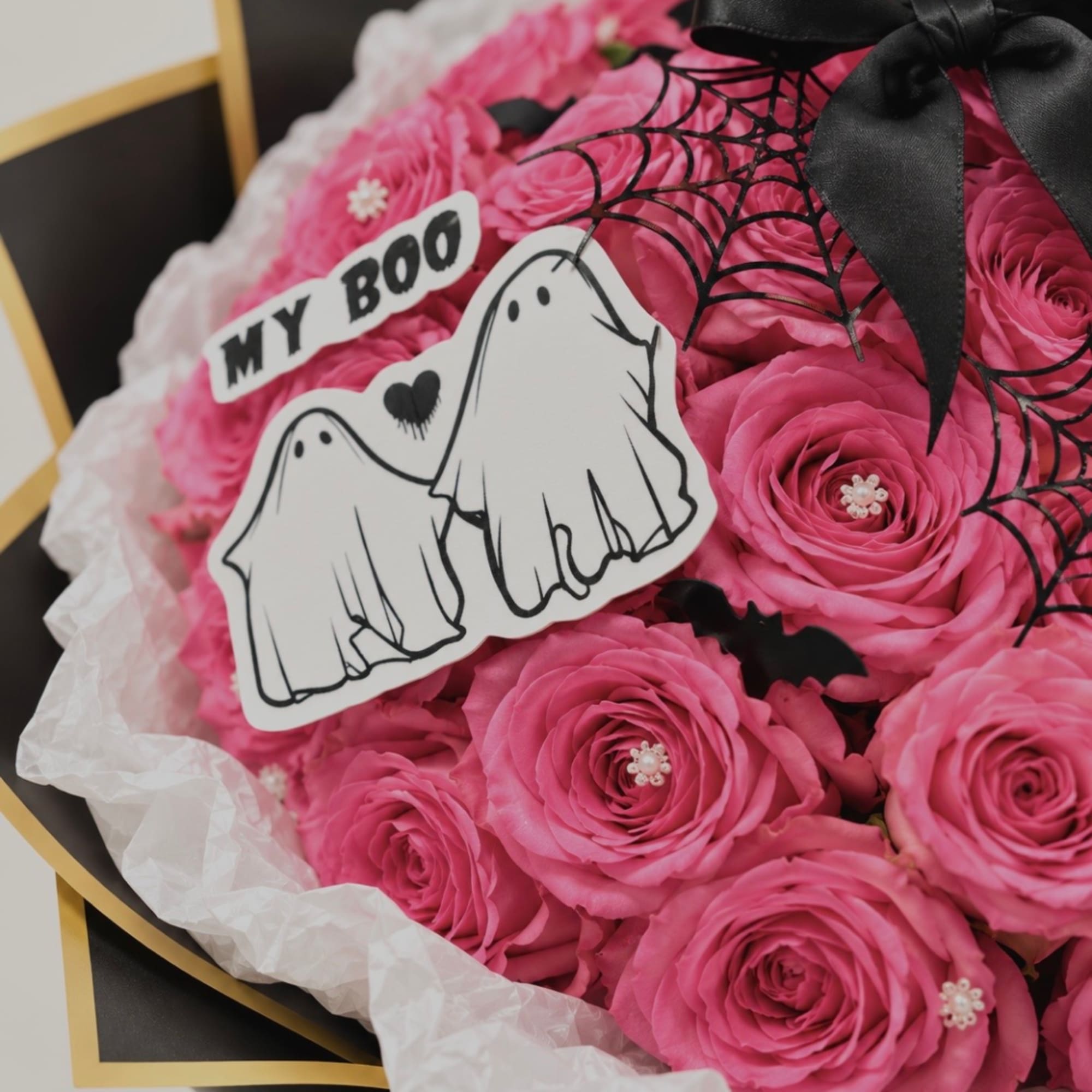 Pink rose bouquet with Halloween ghost decorations and a black ribbon