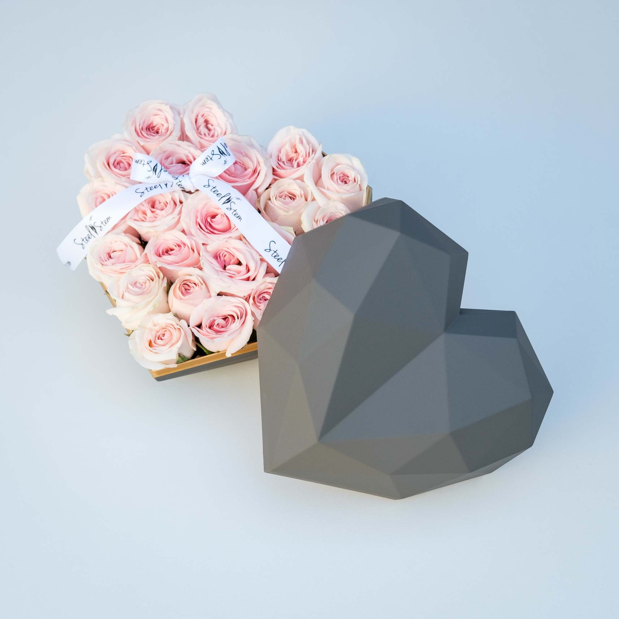 A luxurious heart shaped gift box is filled completely full of pretty