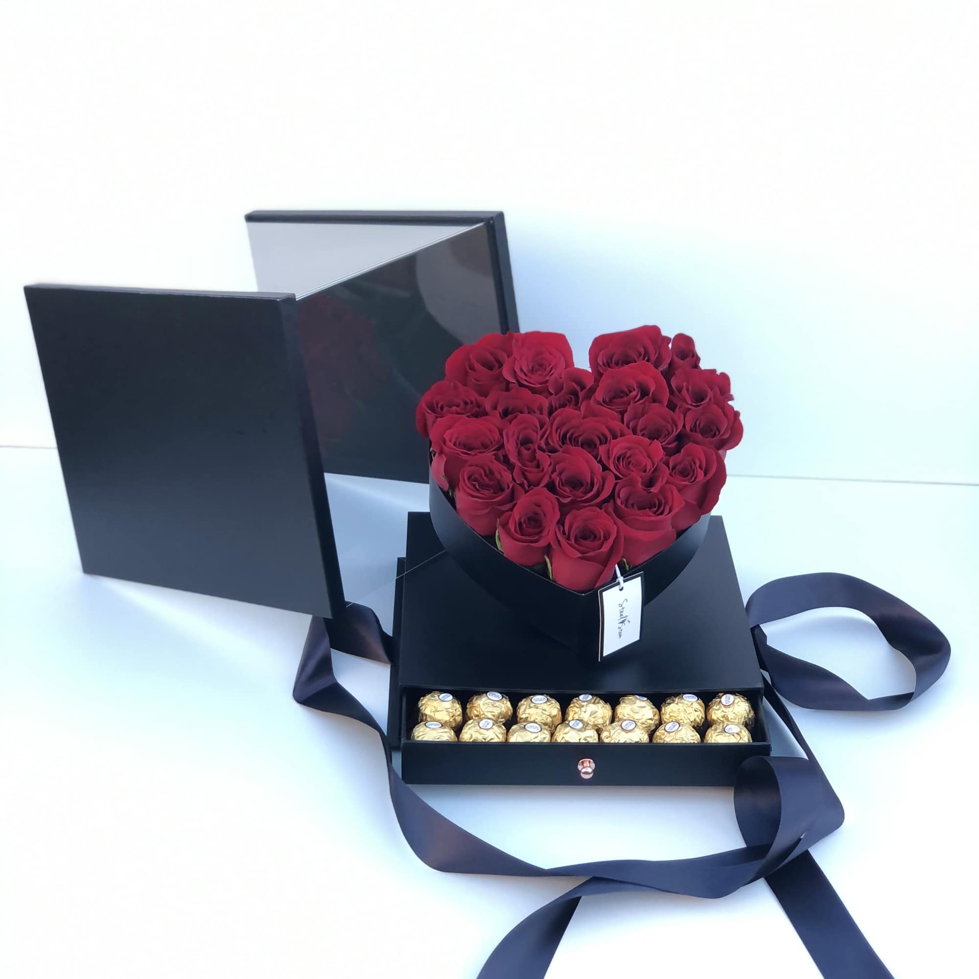 Heart-shaped red rose box with chocolates in a black gift box