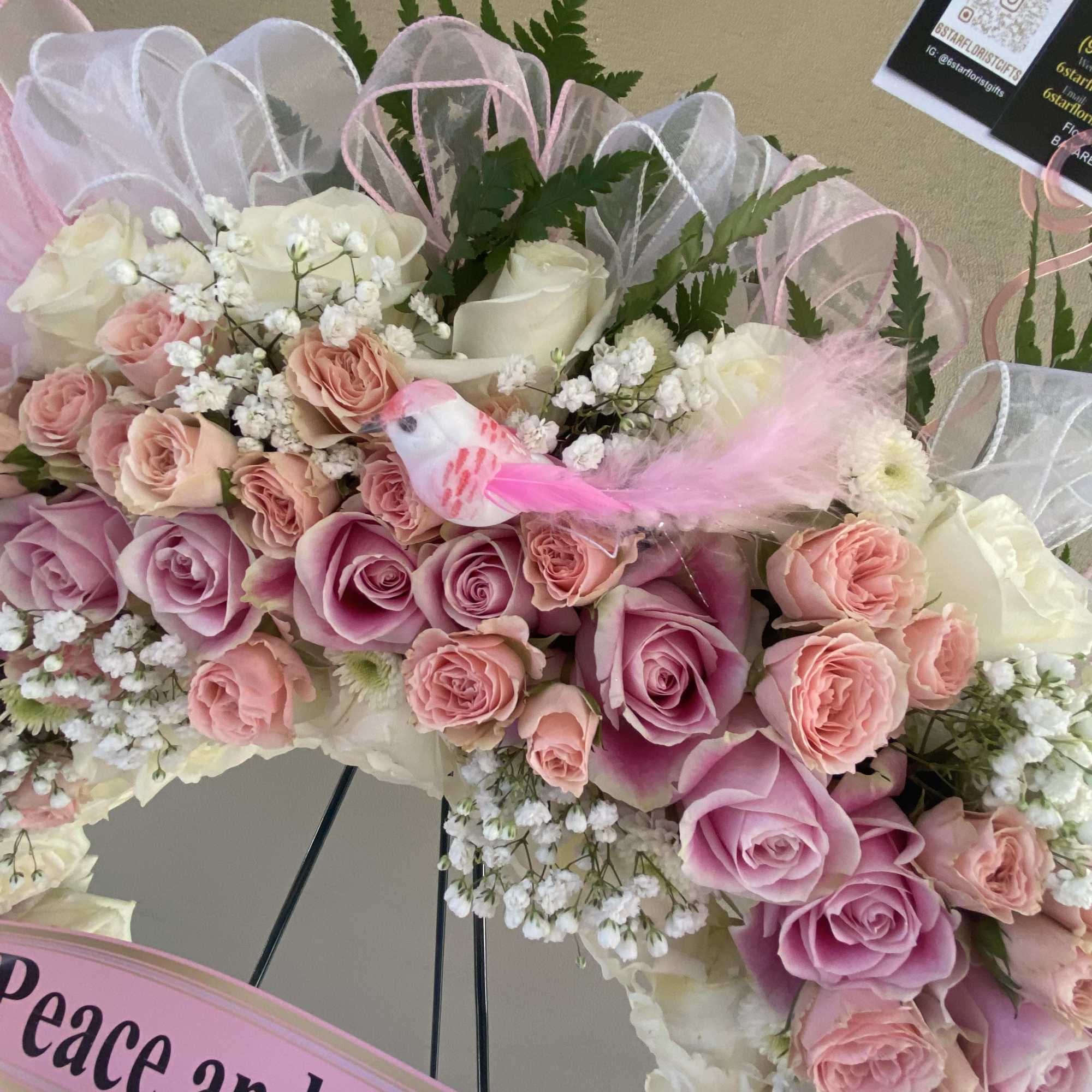 Pink and white rose arrangement with a small bird decoration