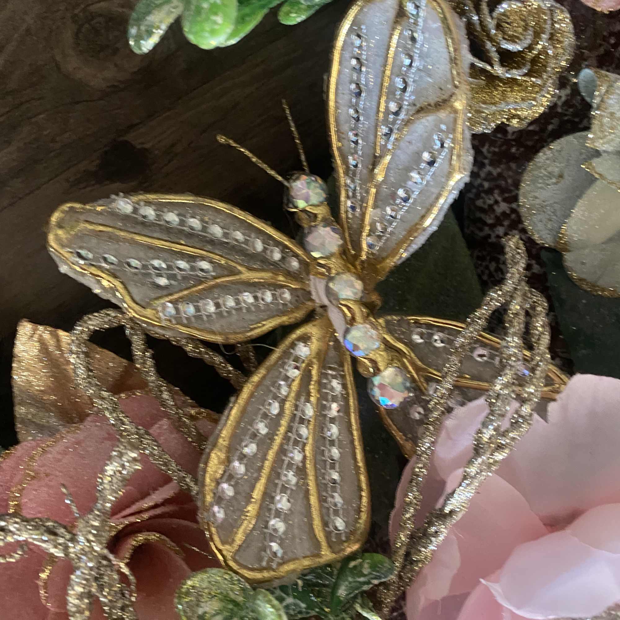 Decorative butterfly ornament with pink flowers and glittery accents