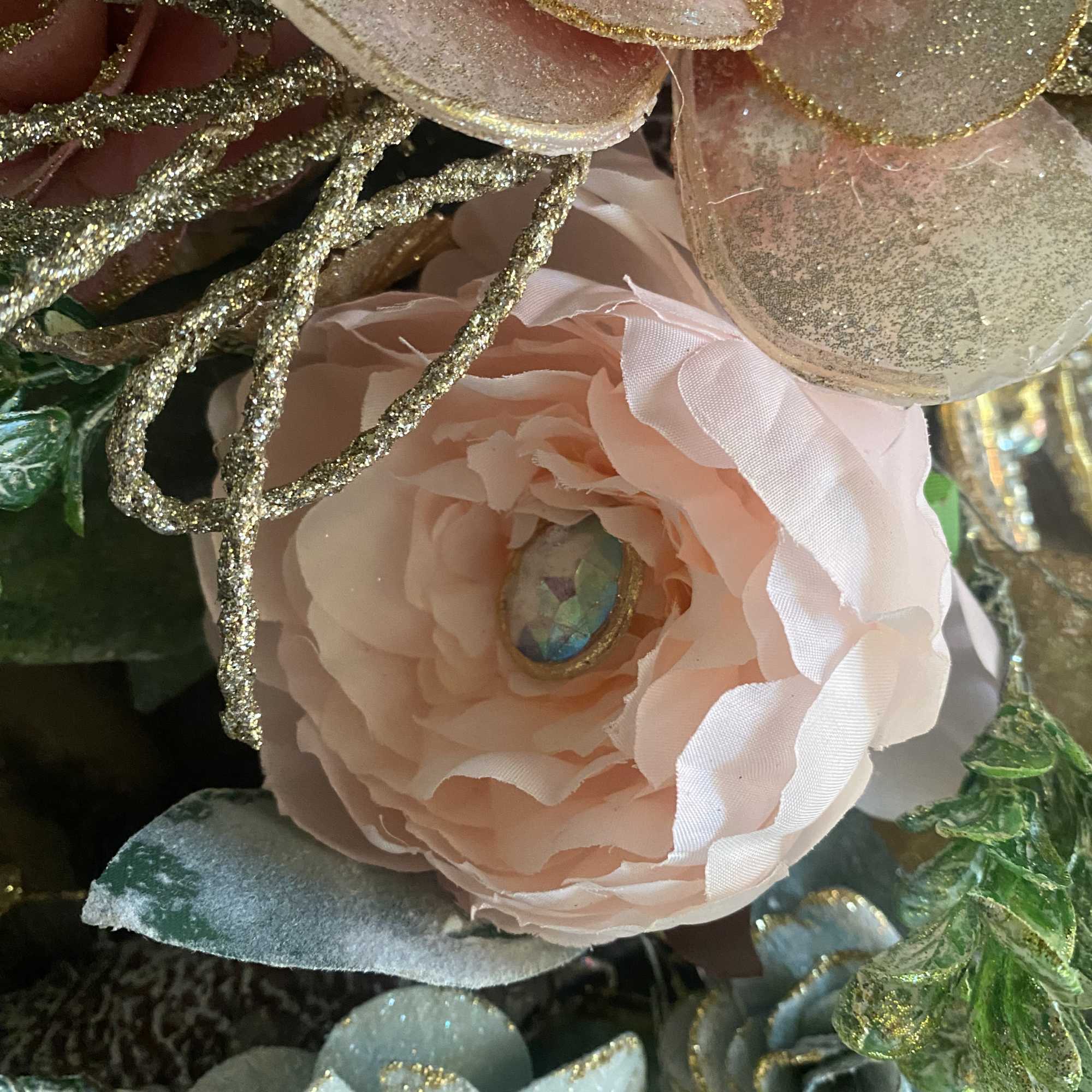Close-up of pastel artificial flowers with glittered petals and leaves
