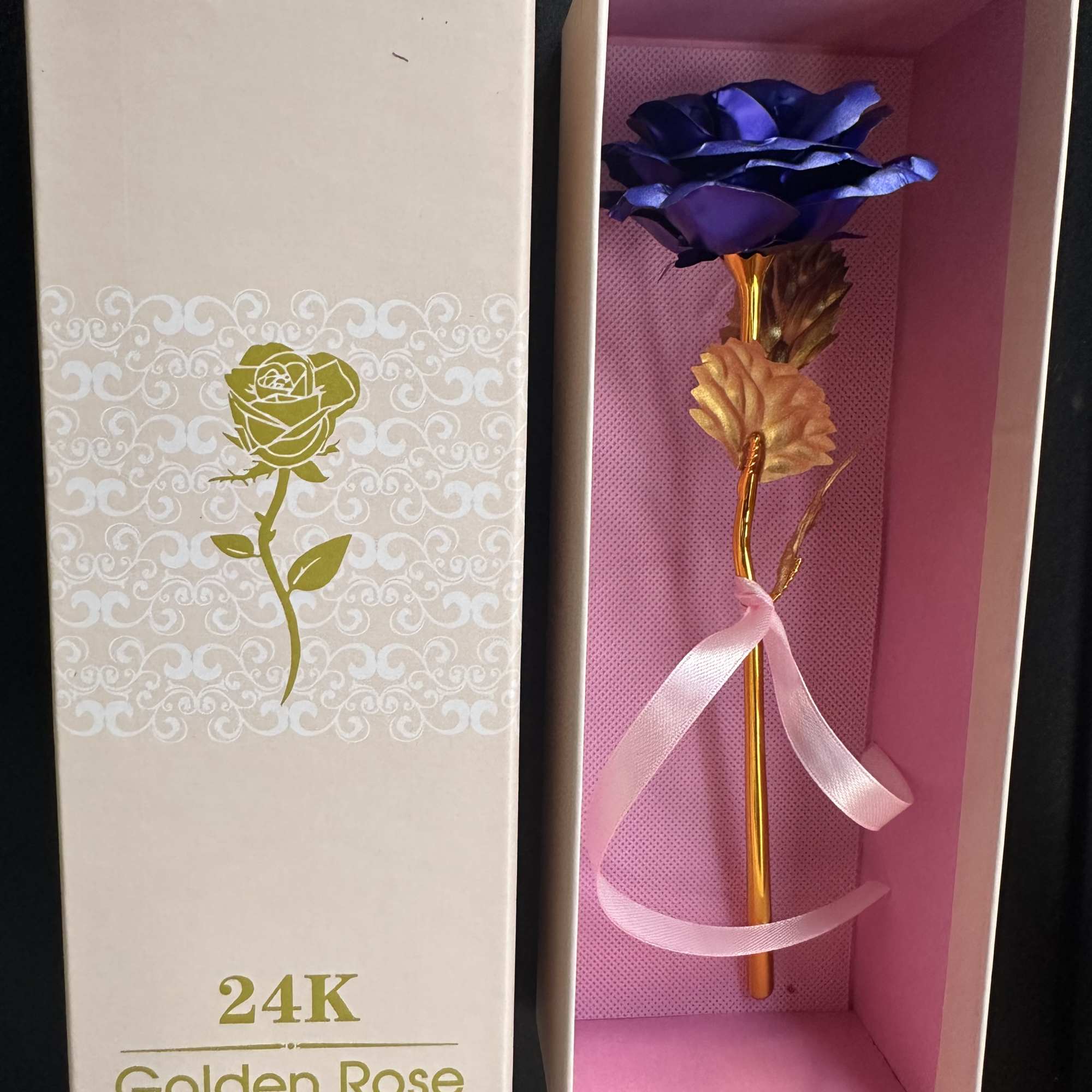 Gift box with a gold stem rose and purple petals inside