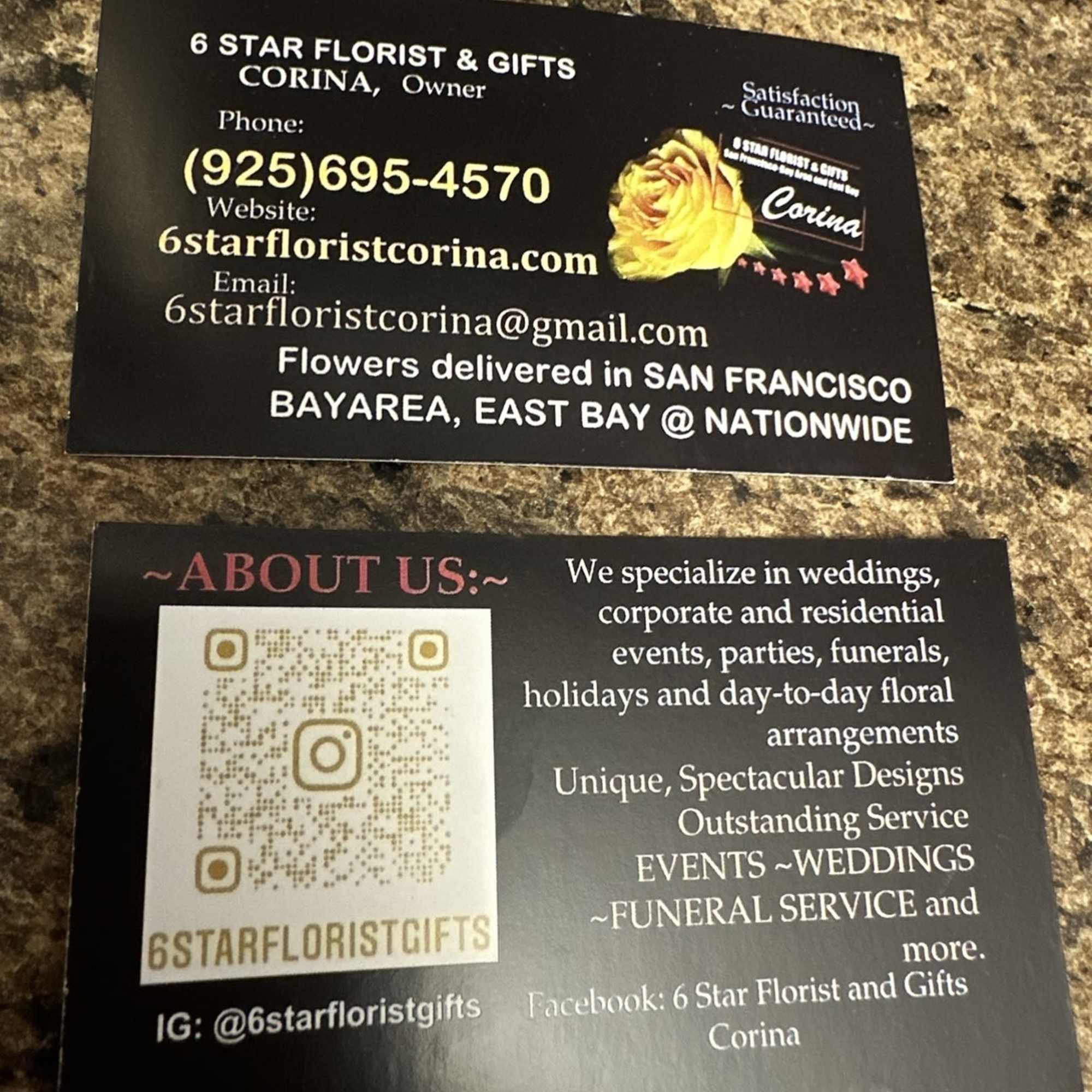 Two florist business cards on a countertop, one with a yellow rose graphic.