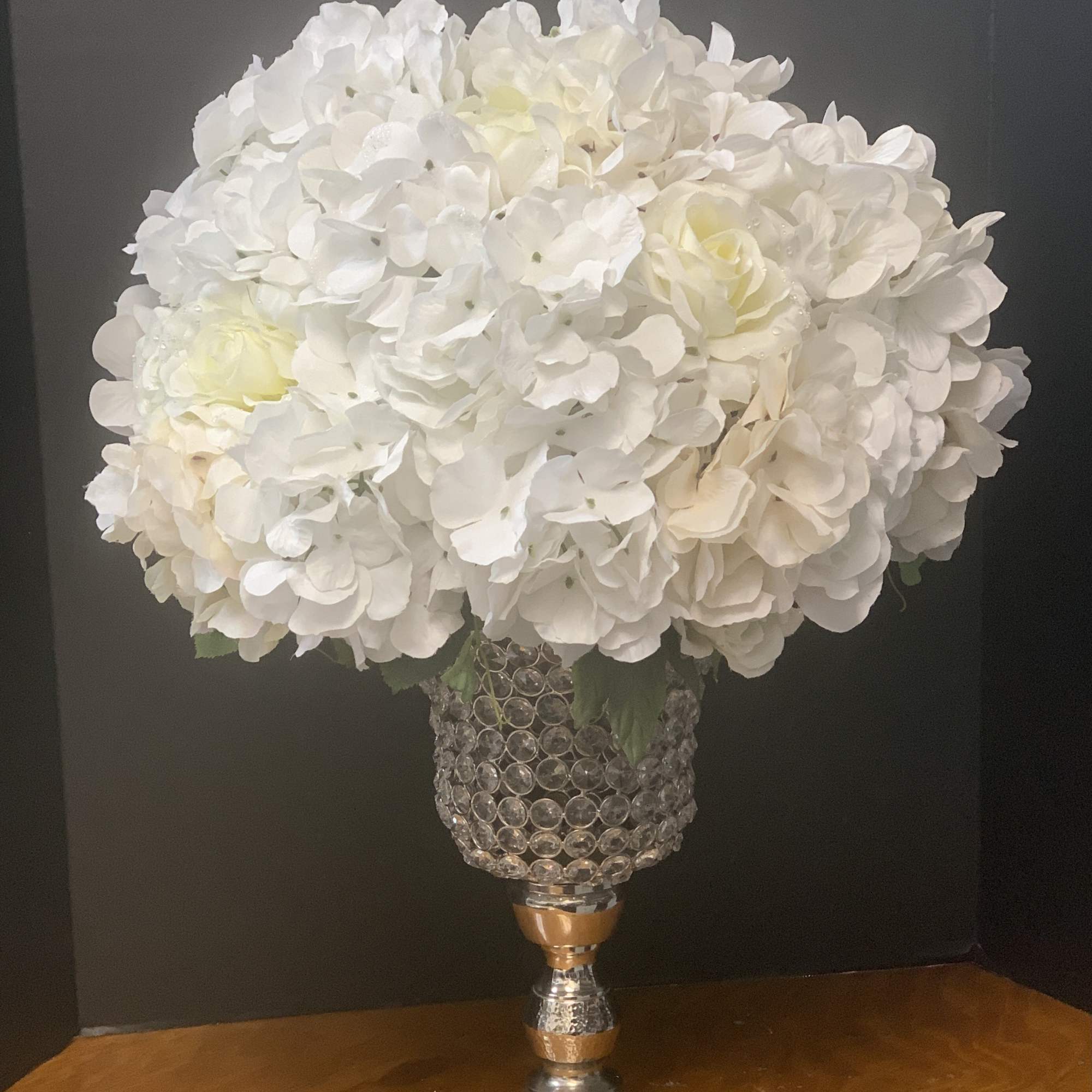 White hydrangea and rose arrangement in a jeweled silver vase