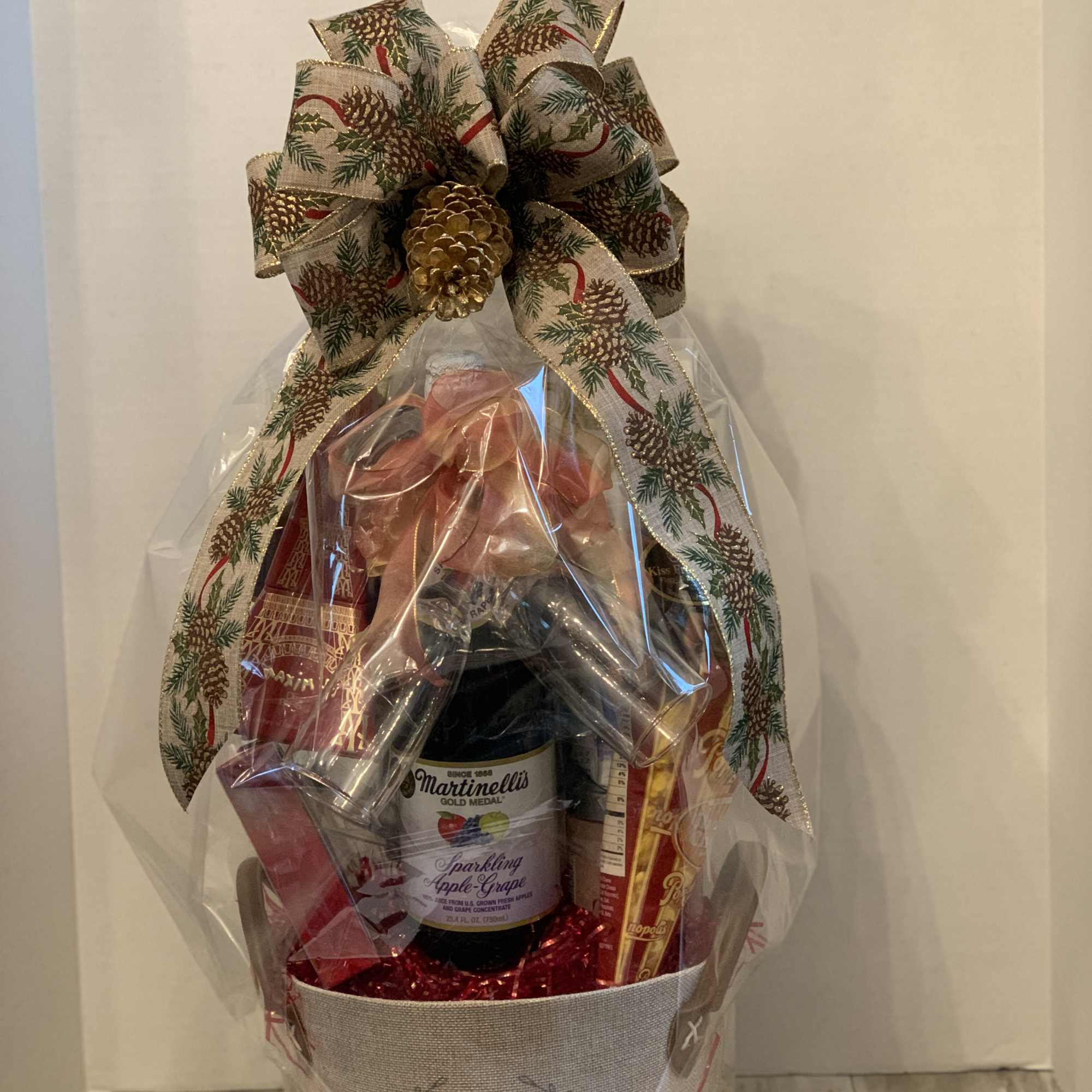 Gift basket with sparkling cider, chocolates, and a large decorative bow