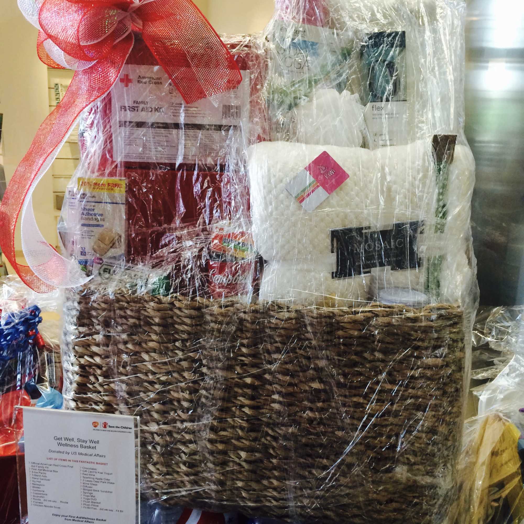 Wrapped wellness gift basket with toiletries and a large red bow