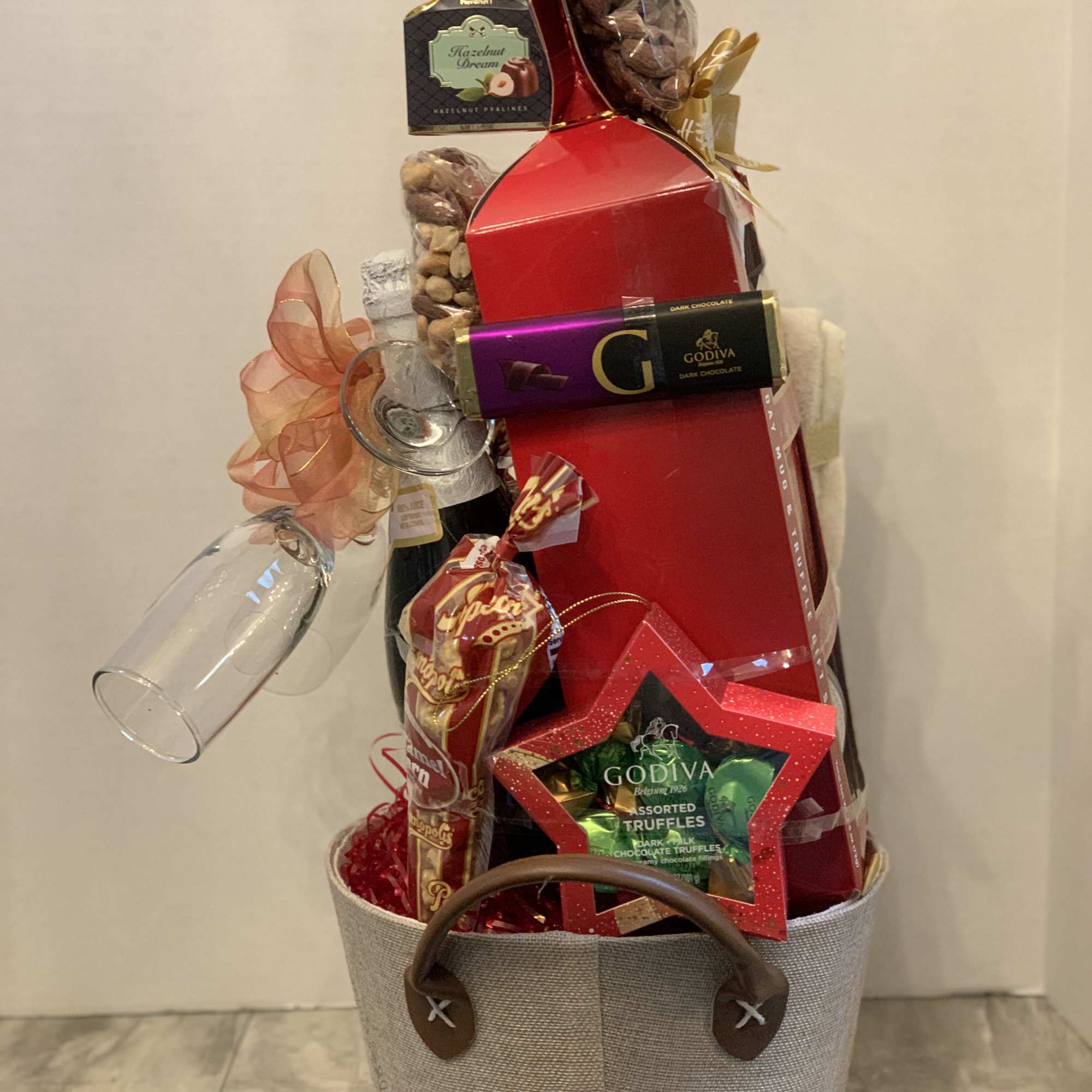 Gift basket with chocolates, nuts, and a wine glass