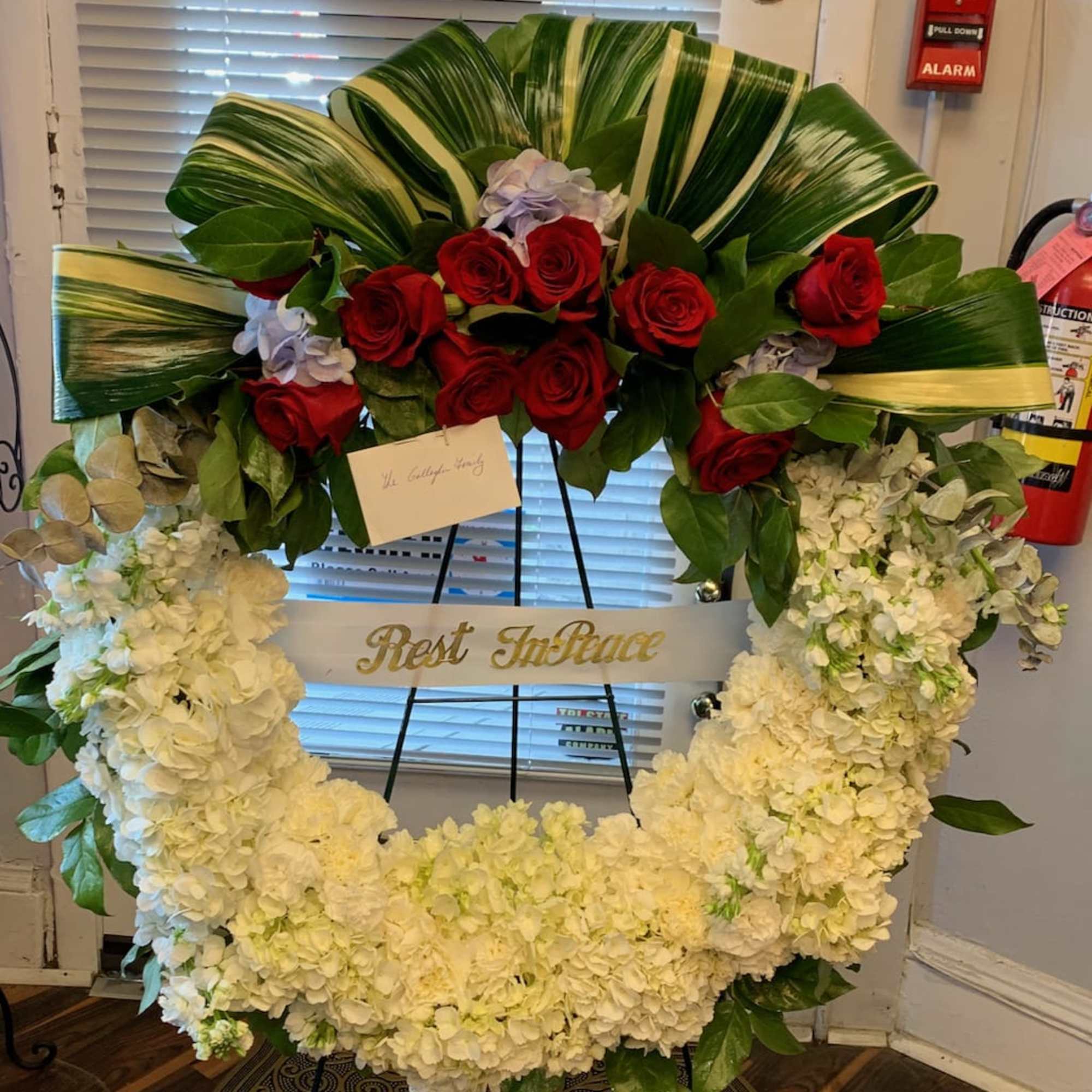 Heart-shaped floral wreath with red roses and white hydrangeas