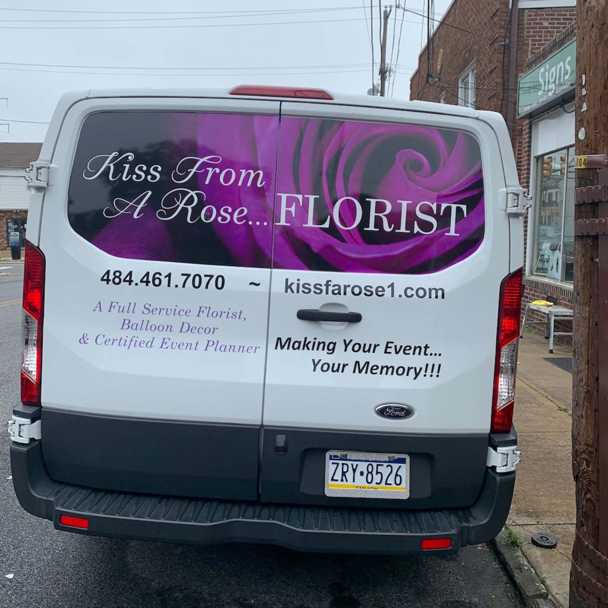 Florist van with purple rose graphics and business text on the back doors