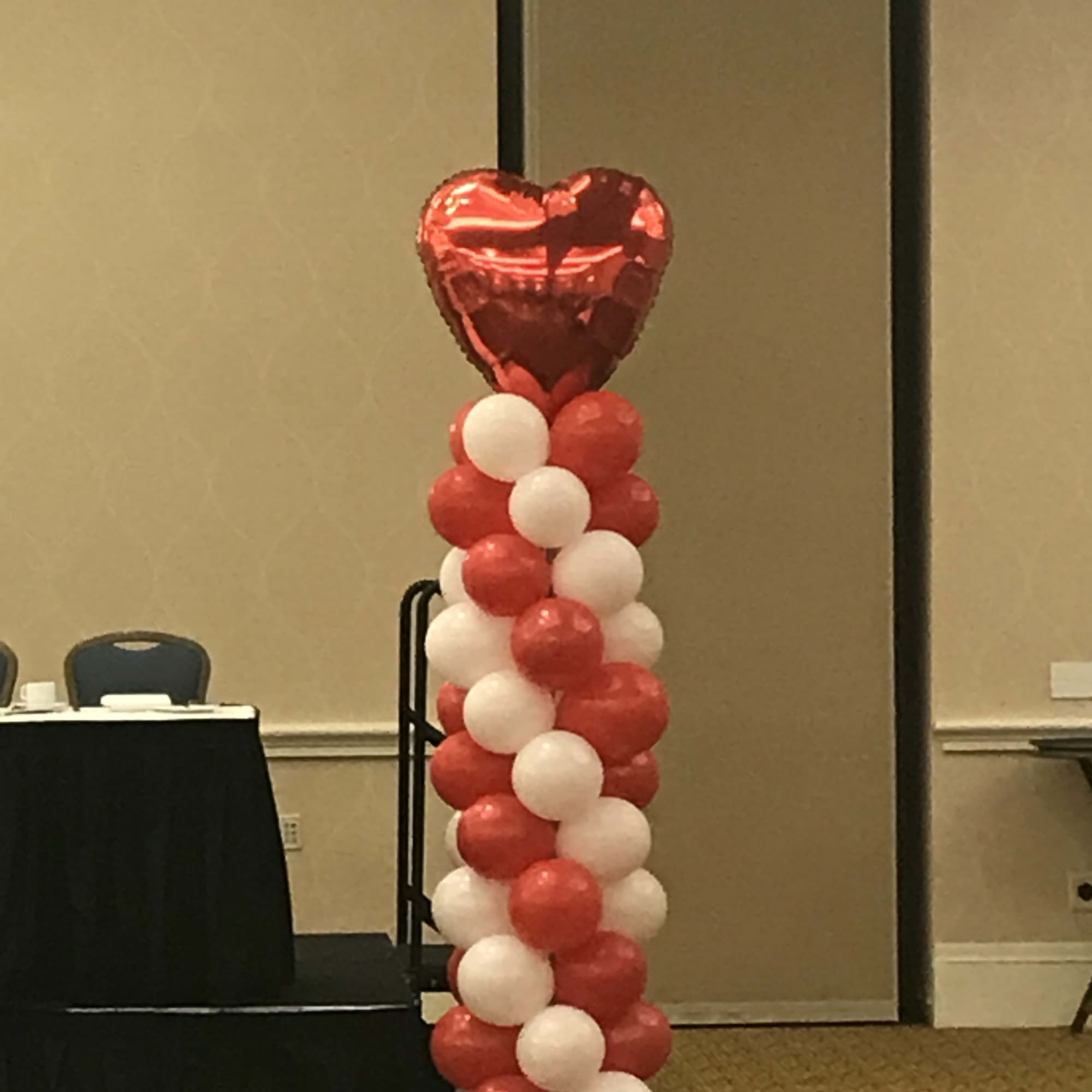 Red and white balloon column topped with a heart balloon